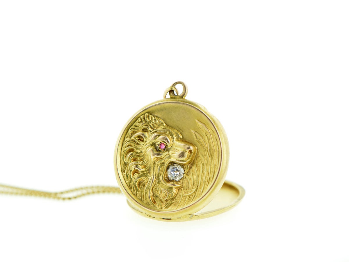 This brave little lion holds a .50ct old Euro diamond in its mouth, with a ruby set into the eye. The 14k yellow locket hangs from an 18k yellow gold curb chain and measures just a little over 18