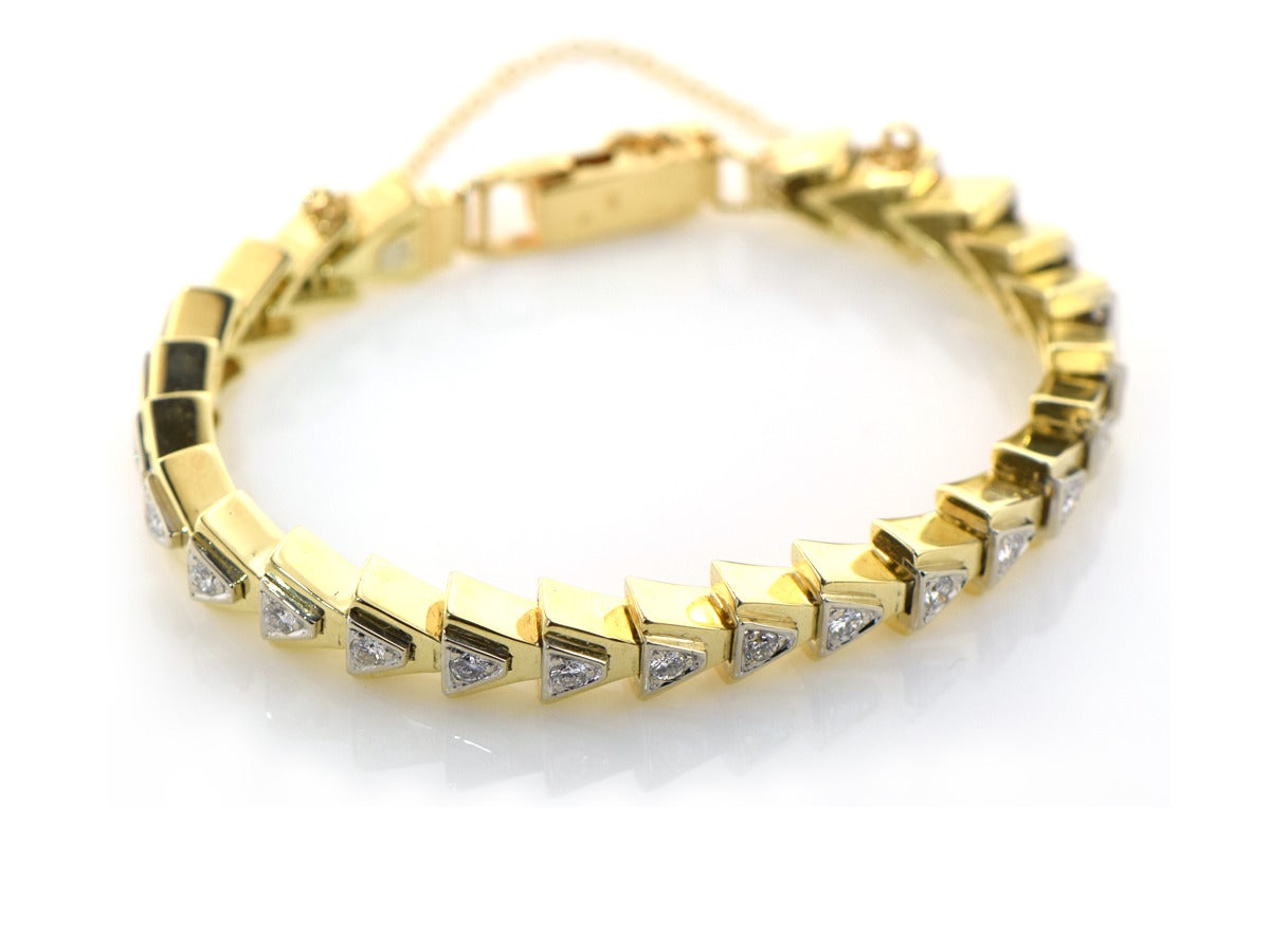 This fun gold triangle link bracelet features over 1 ct worth of diamonds set into 14k white and yellow gold. The clasp is extra secure with a fold over tab and safety chain.