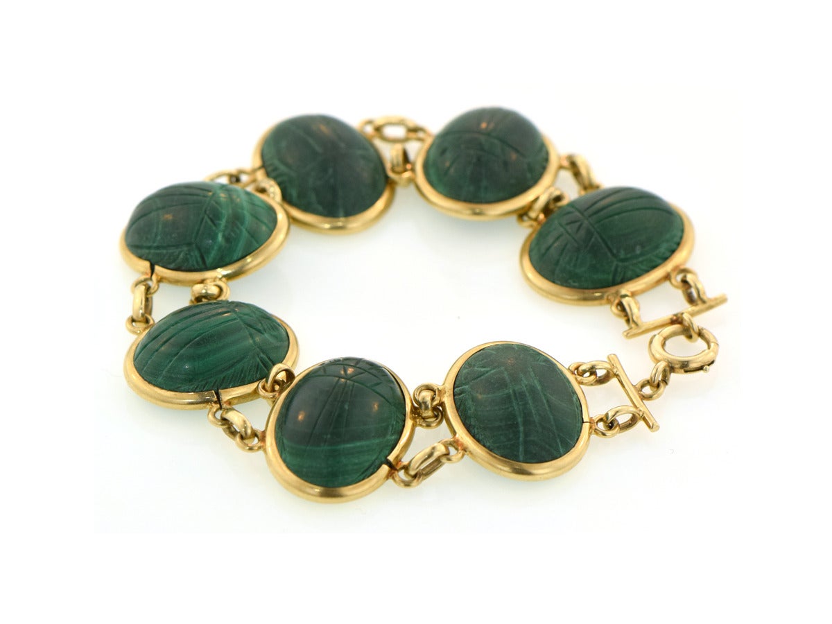 The discovery of King Tut's tomb was the source of inspiration for this elegant and simple gold bracelet.  Each individual 14k gold link sets a hand carved green malachite scarab beetle.