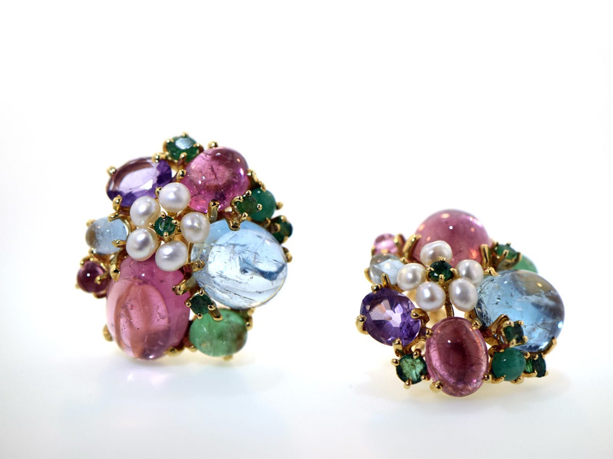 This gorgeous melange of color and materials will surely bring a smile to anyone.  These ear clips are made of 14k yellow gold and set a mix of tourmaline, aquamarine, and emerald cabochons along with some full cut emerald and amethyst stones.  The