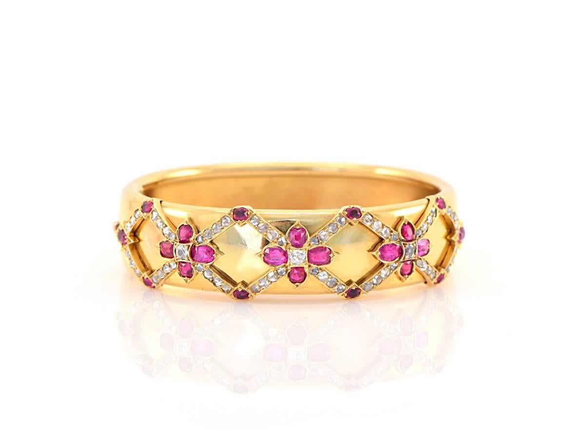 An English delight!  This beautifully sculpted gold bangle sets a lattice motif on the surface, covered in bright white rosecut diamonds and oval rubies.  The quality is impeccable...

*14k yellow gold 
*width measures .75