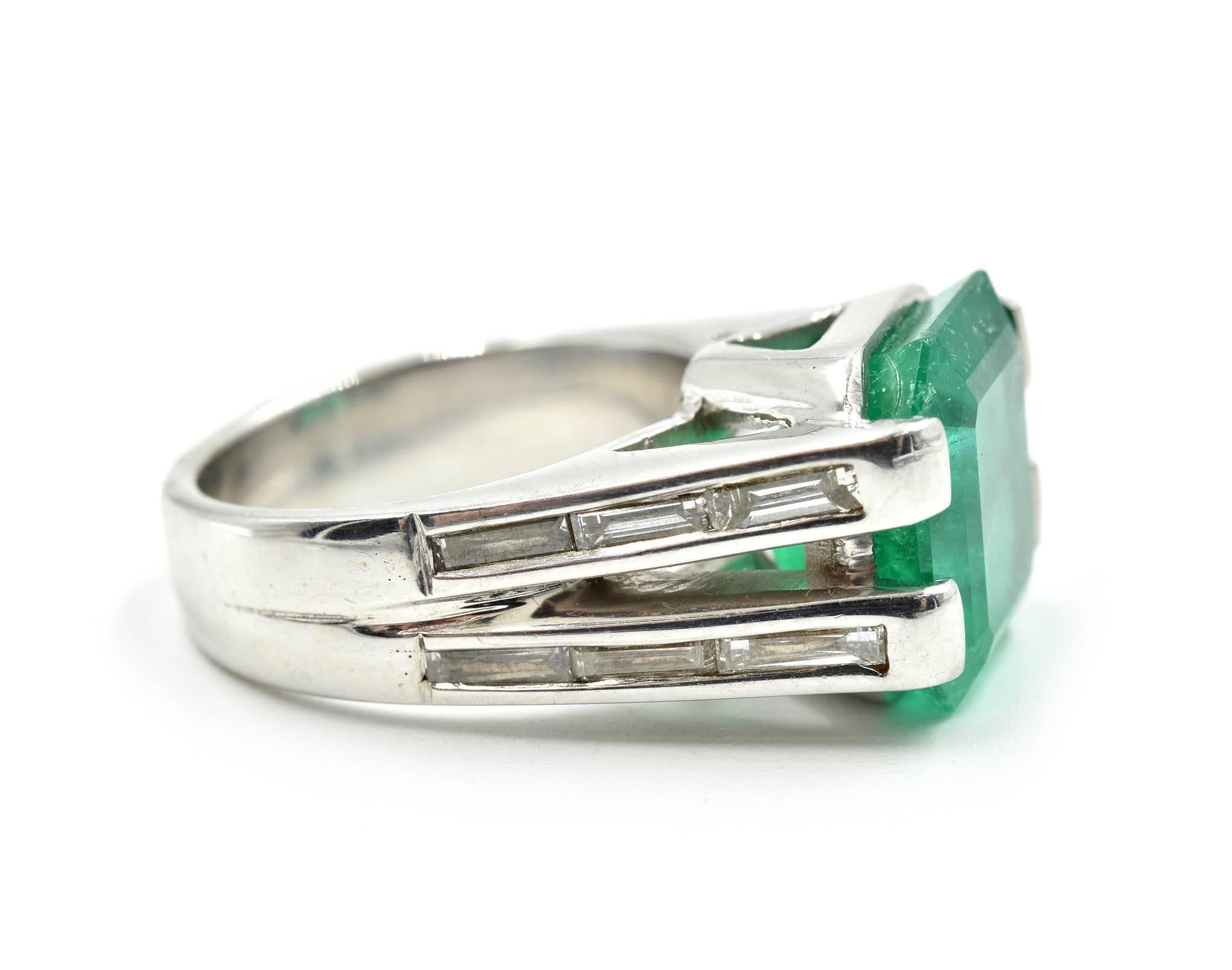 Designer: custom design
Material: 18k white gold
Emerald: transparent step-cut 6.86 carat emerald
Diamonds: 12 baguette cuts = 1.00 carat total weight
Color: H-I
Clarity: VS
Dimensions: ring top is 12.11mm long and 13.89mm wide
Ring Size: ring size