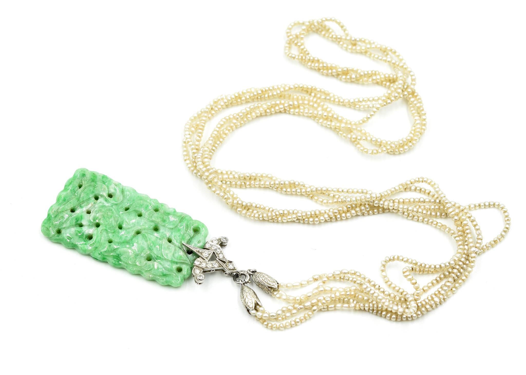 Introduced and designed by elite designer… Tiffany & Co! This is a 24” inch multi-strand of seed pearls with a diamond set, jade pendant, made in platinum! The jade pendant is designed with a diamond set platinum bail. The bail is made with a