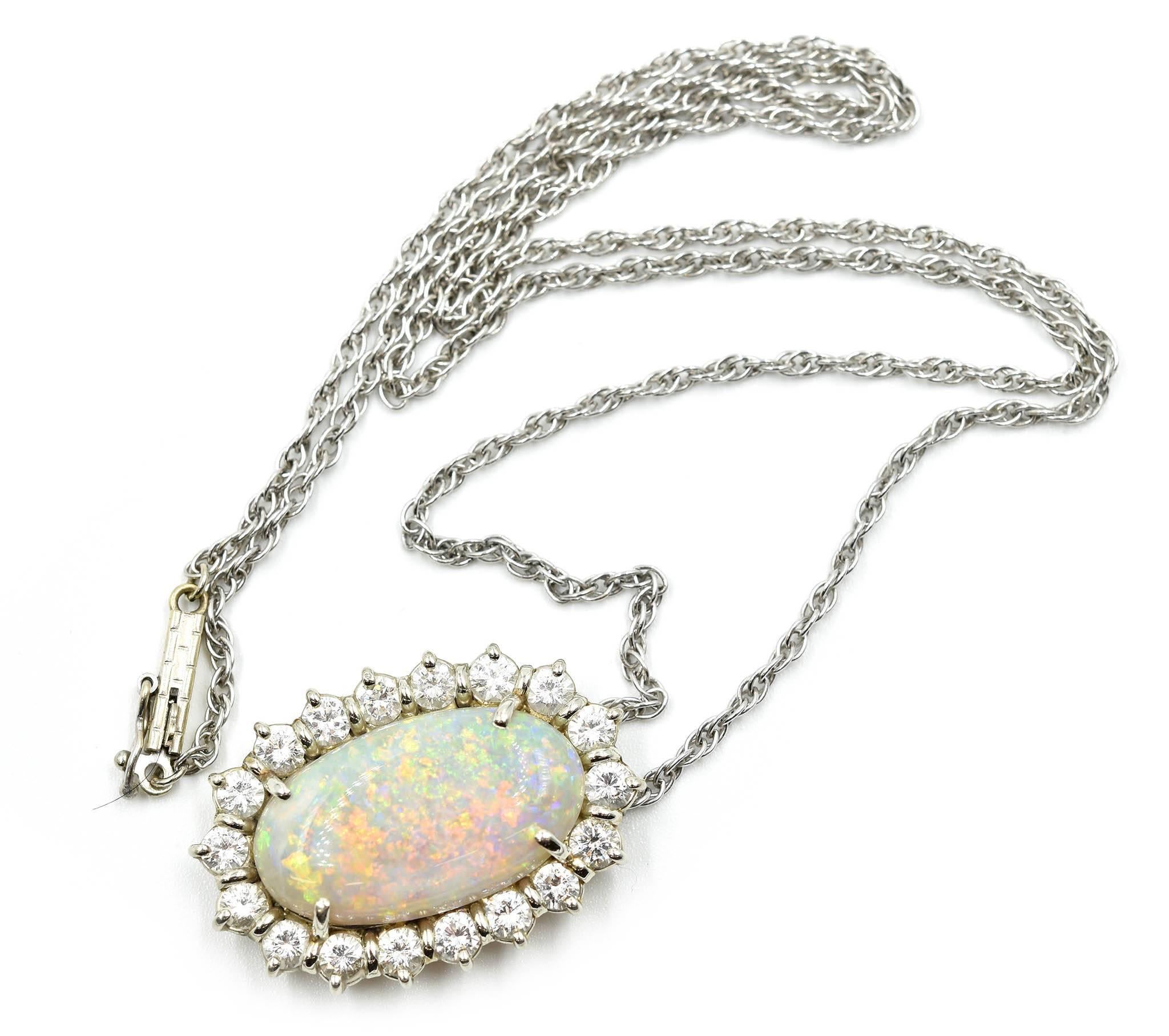 This fabulous necklace is made in solid 14k white gold, and it holds an oval-cut opal at its center. The opal measures 20.5x12.2mm. It is surrounded by a halo of round diamonds for a total weight of 1.80ct. The diamonds are graded G-H in color and