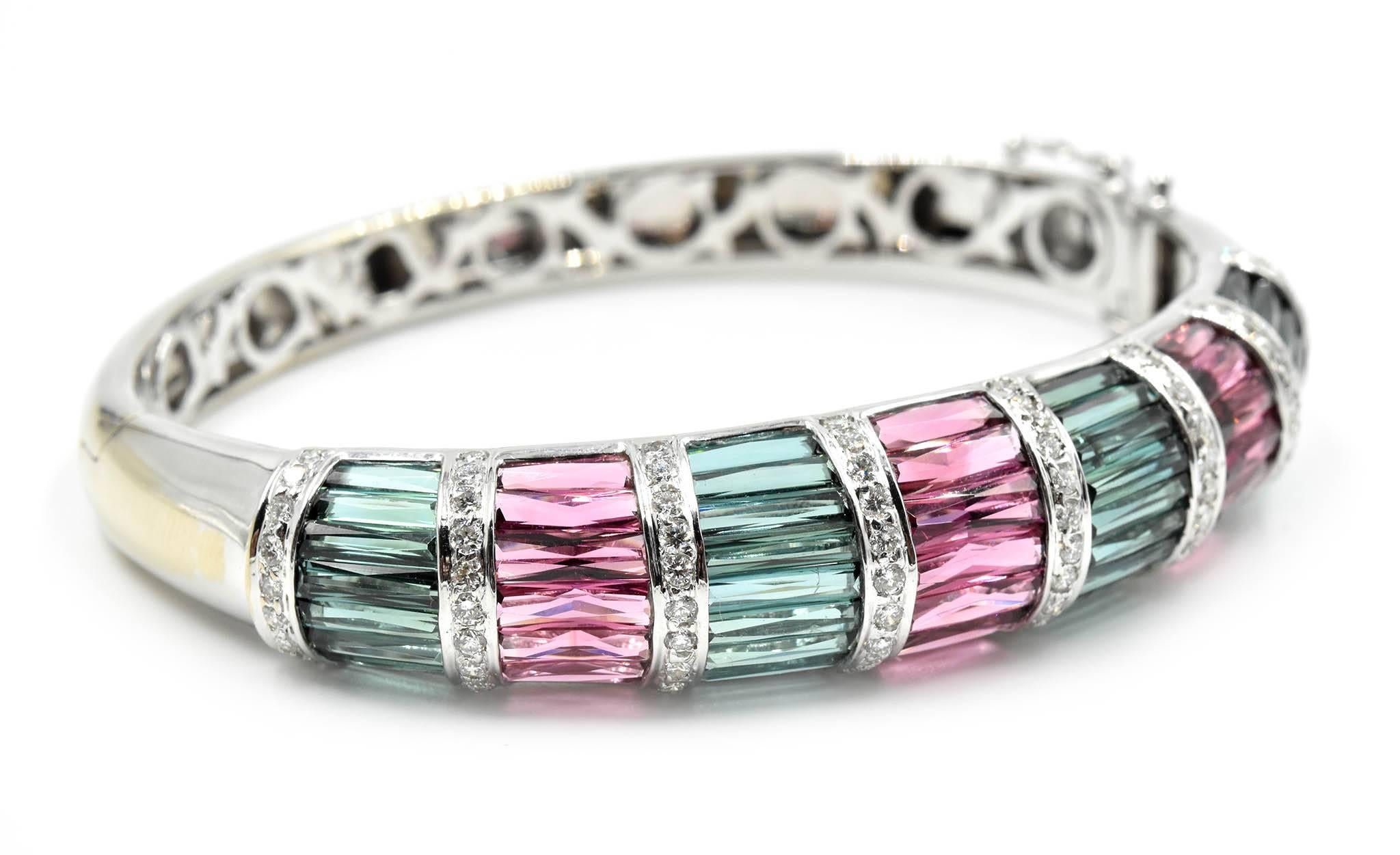 Designer: custom design
Material: 18k white gold
Diamonds: 74 round brilliant cuts = 1.11 carat total weight
Tourmaline: Pink and Turquoise tourmaline
Color: G-H
Clarity: SI
Dimensions: bangle will fit up to 6.5 inch wrist, top of bangle is a ½ inch