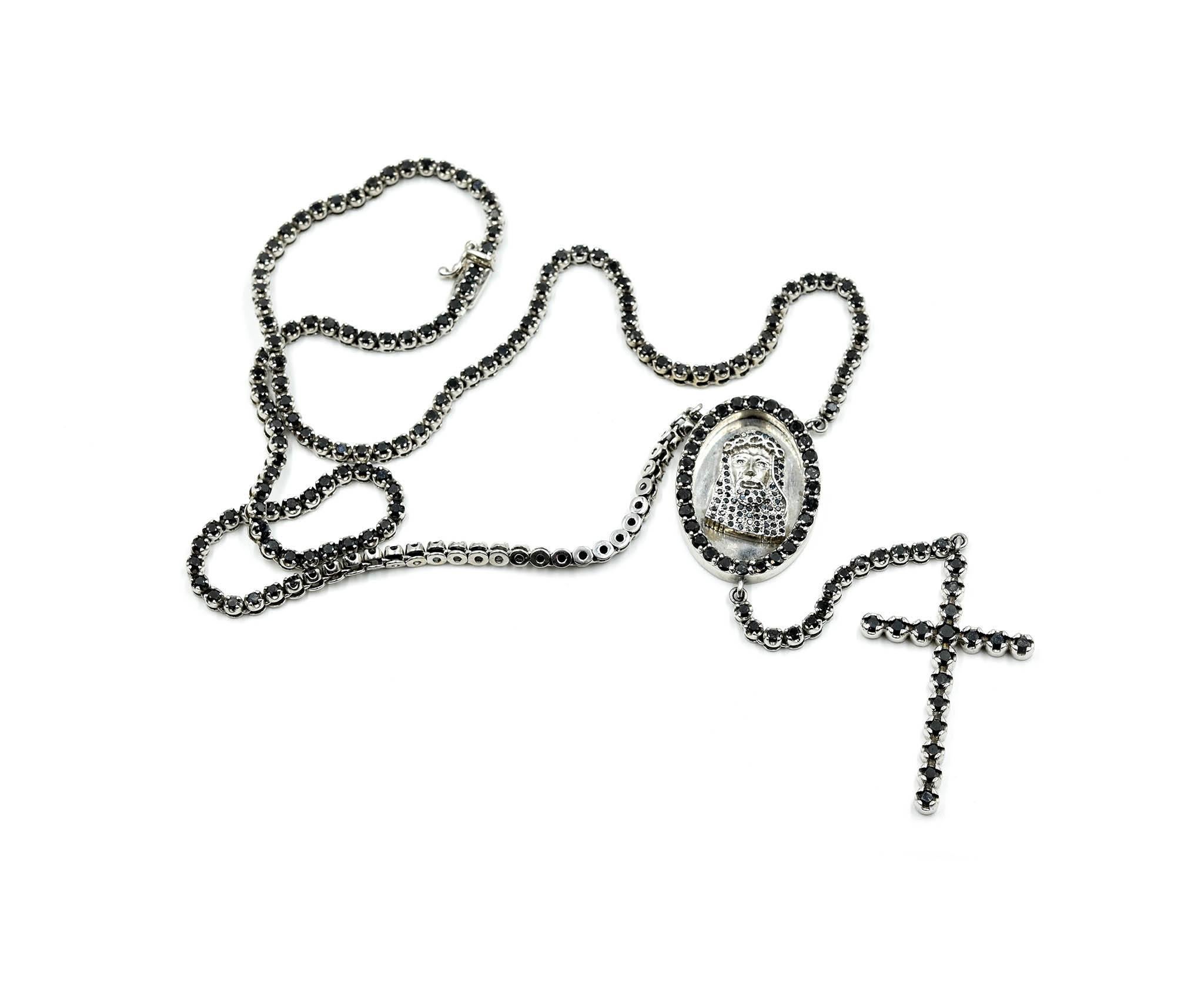 Designer: Johnny Dang
Material: 10k white gold
Diamonds: round brilliant black diamonds
Dimensions: necklace is 24 inches long, cross dangles 3 ¾ inches, Jesus pendant measures 1 ½ inch long by 1 inch wide 
Weight: 68.54 grams
Retail: $8,500
Box