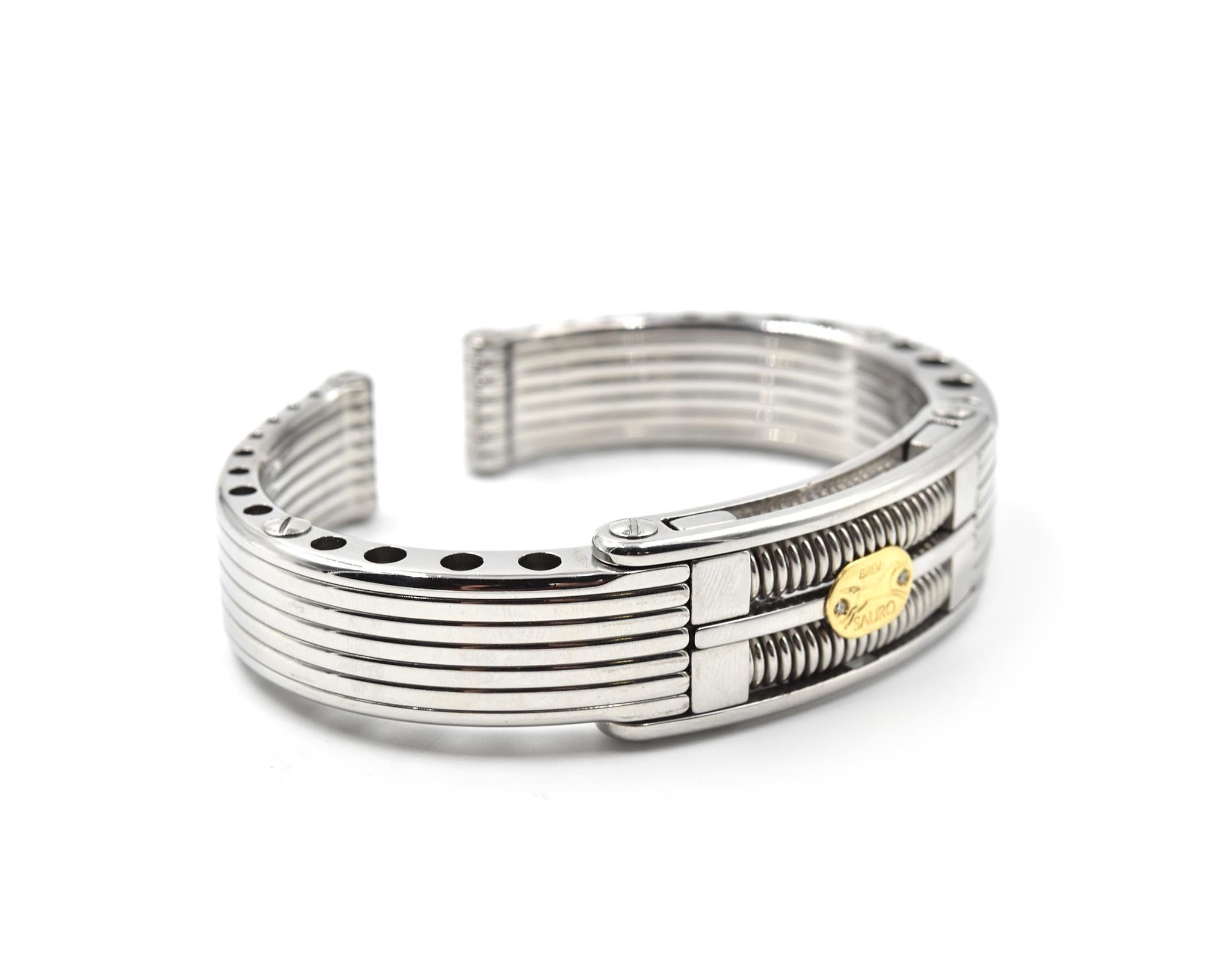 Designer: Sauro
Material: stainless steel with 18k yellow gold plate
Diamonds: two bead set round diamonds = 0.02 carat total weight
Size: bracelet will fit 7 1/4-inch wrist
Dimensions: bracelet is 17.95mm wide
Weight: 96 grams
