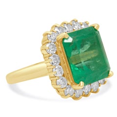 Anillo de oro amarillo de 18 quilates con esmeralda de talla esmeralda y halo de diamantes redondos