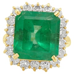 Anillo de oro amarillo de 18 quilates con esmeralda de talla esmeralda y halo de diamantes redondos
