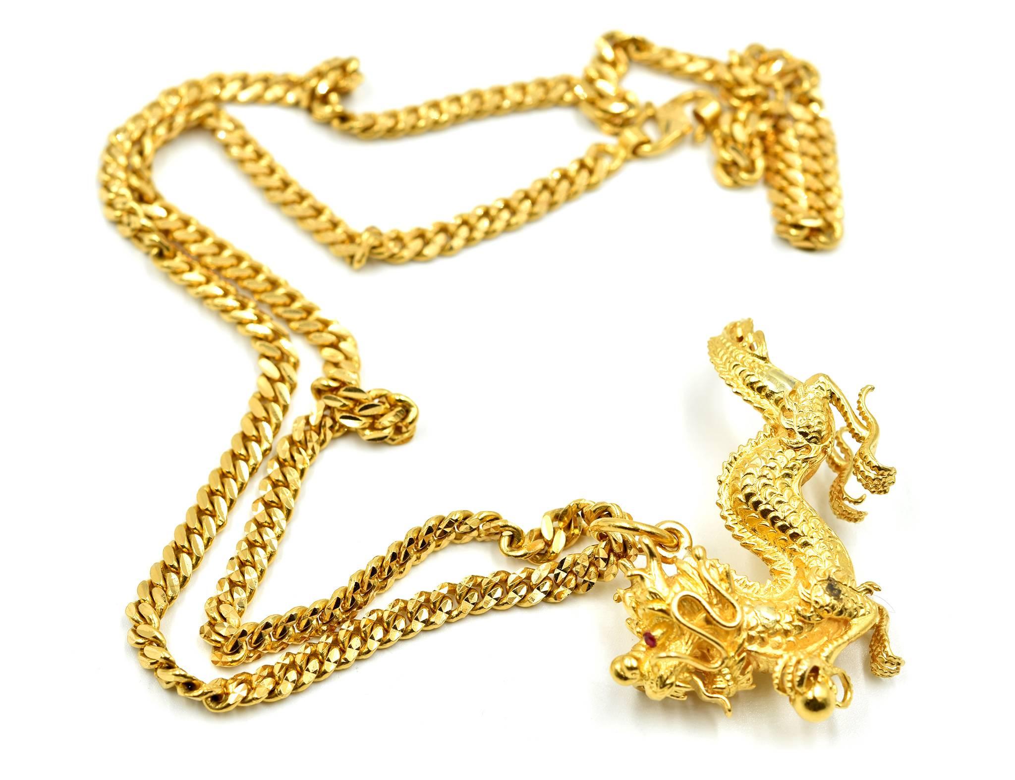 This ferocious 22k yellow gold necklace, is headlined by the intricately crafted oriental ruby set dragon! The dragon is made with a scaly back, piercing in the tail, etched and granulated claws, with a high polished orb set in the dragon’s left