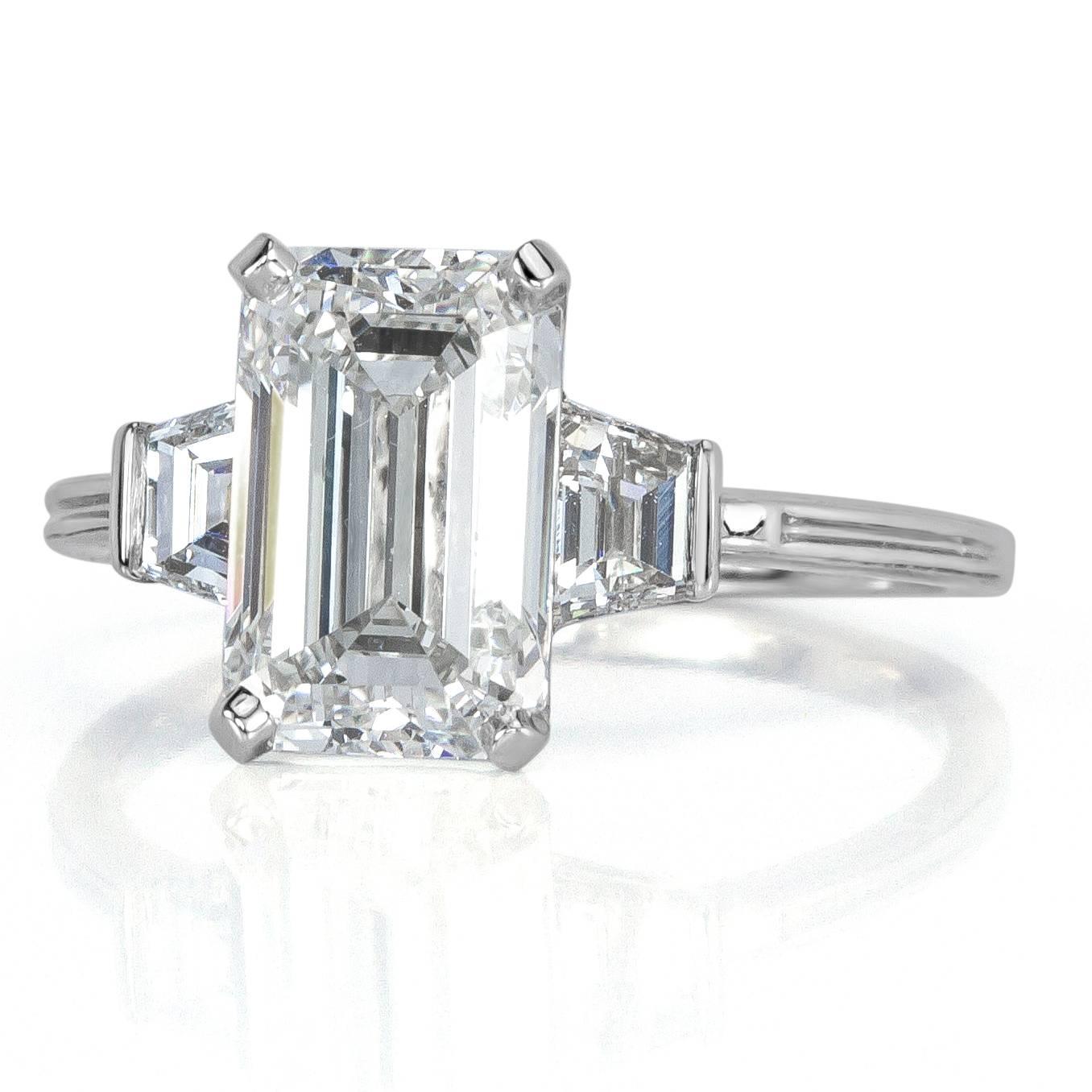 This gorgeous emerald cut diamond ring is a masterpiece. It showcases a stunning 3.02ct emerald cut diamond, GIA certified at H-VVS2. It is incredibly white and clear with an exceptionally elongated cut measuring 10.03 x 6.51 mm. It is beautifully