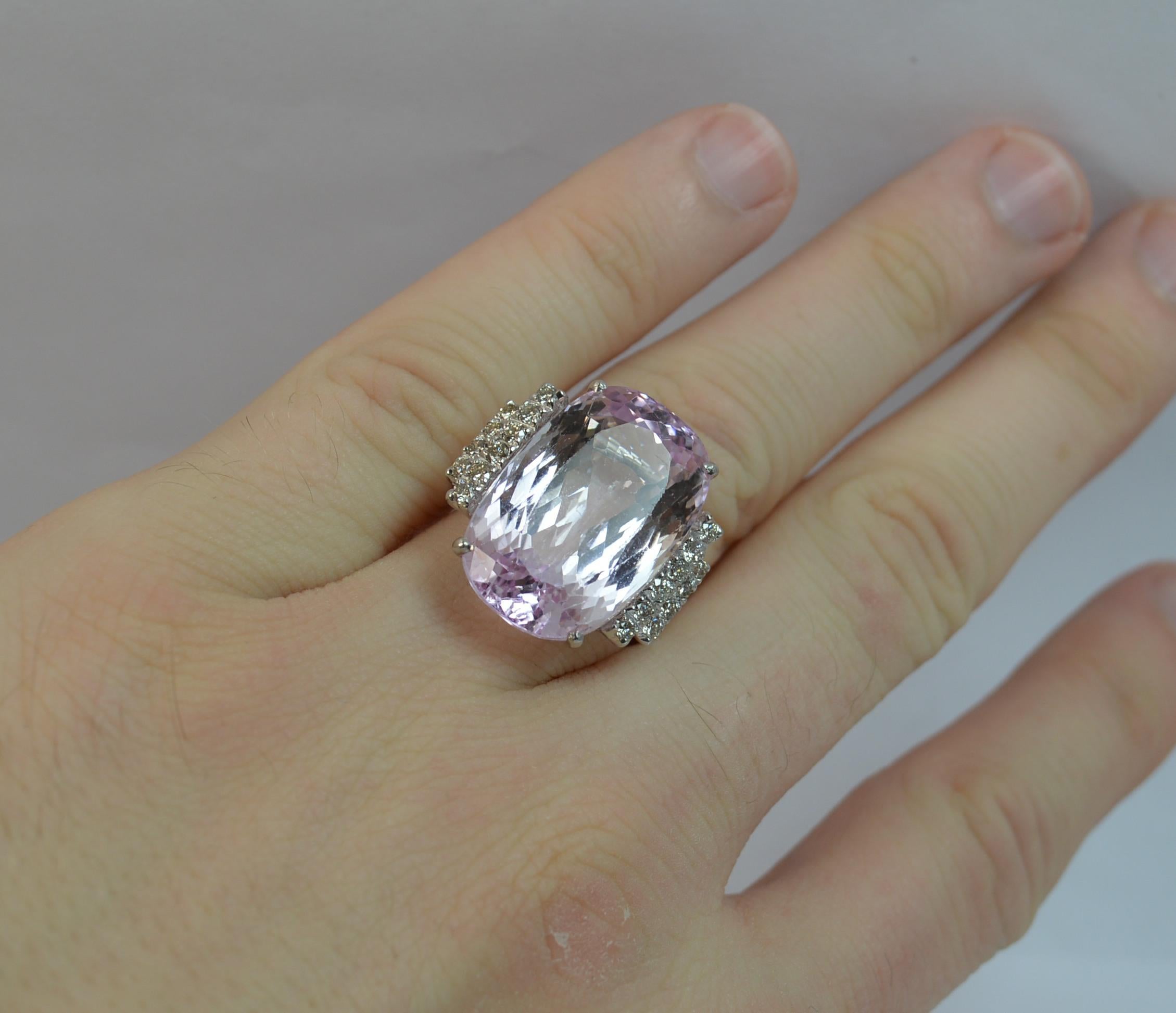 A stunning ladies cocktail ring.

Set with a very large oval cut Kunzite to the centre in four claw setting. 14.2mm x 21.2mm approx.

10 round brilliant cut diamonds to each side of geometric shape.

A seriously impressive ring with beautiful pink