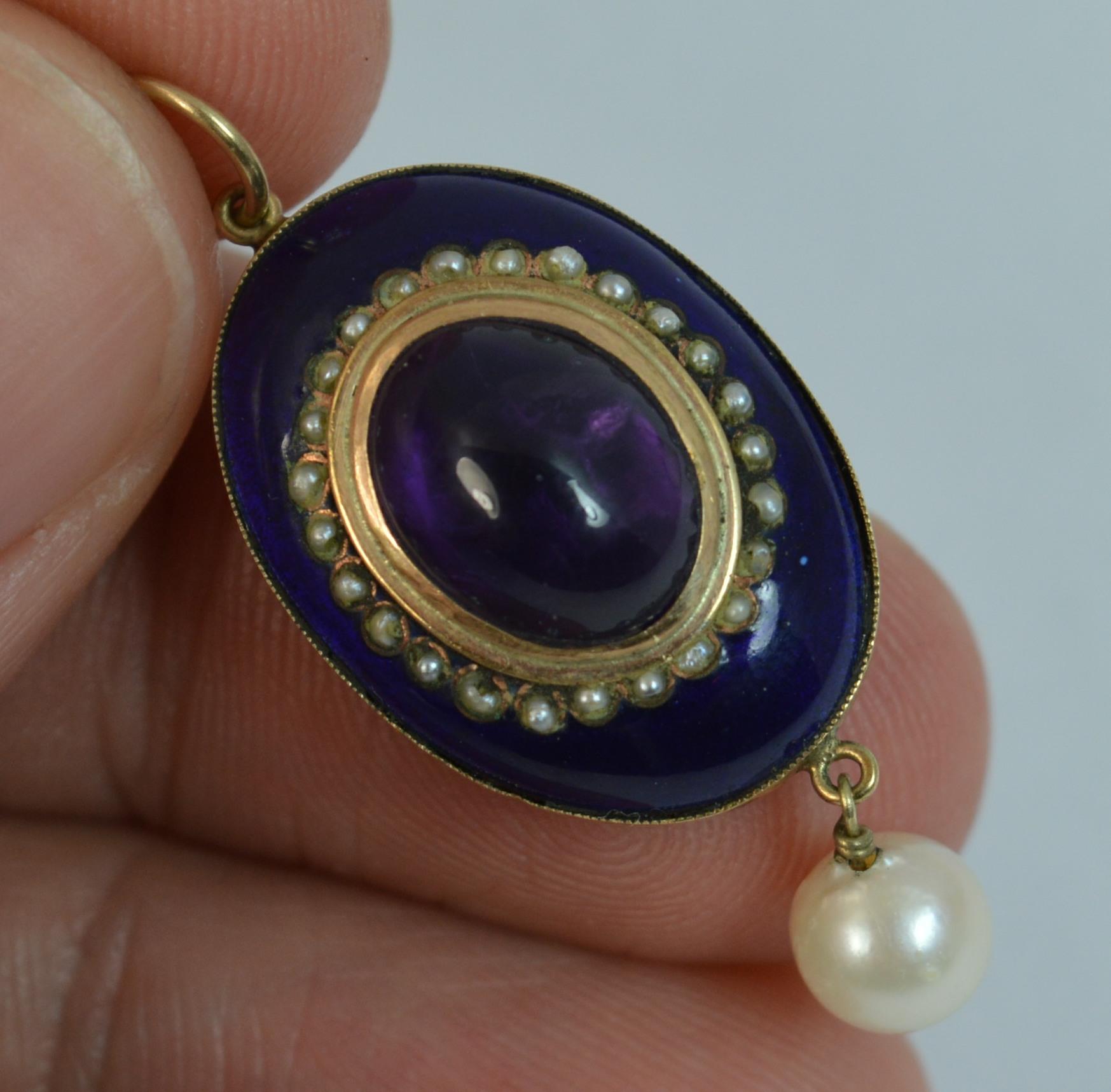 
A true Victorian period pendant.

Solid 9 carat rose gold example.

Designed with an amethyst cabochon to the centre with seed pearl border surrounding and blue enamel finish to each side. The piece is complete with a pearl drop to the