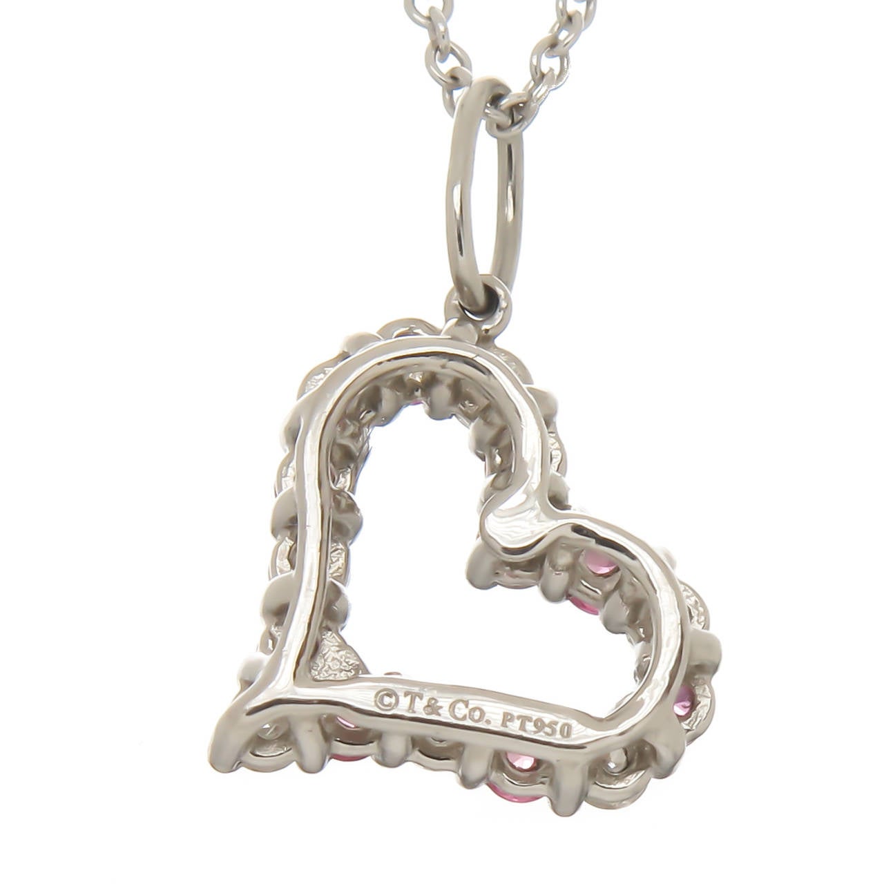Circa 2014 Tiffany & Company Platinum open heart Pendant, set with Round Brilliant cut Diamonds and pink Sapphires, Suspended from an 18K White Gold Tiffany Chain. Pendant measures 1/2 Inch. Original Tiffany Presentation Box.