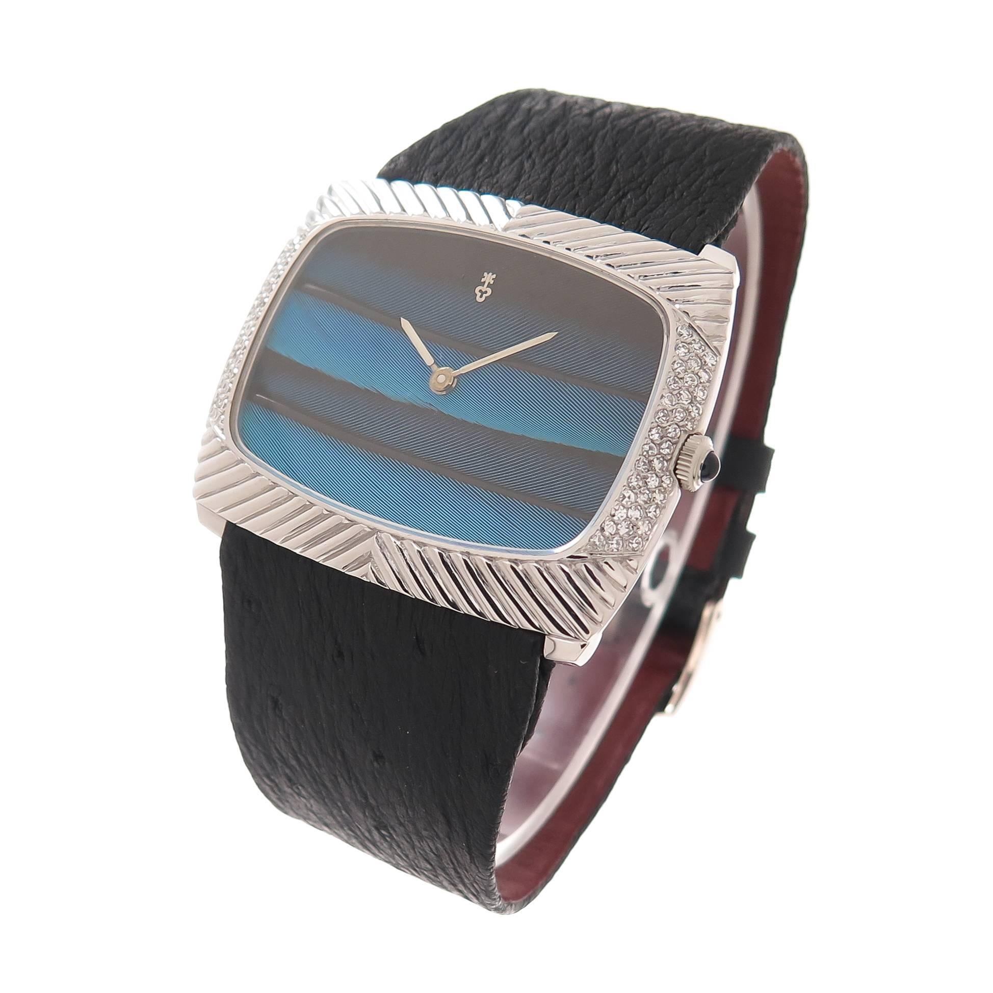 Circa 1970 Corum over-sized 18K White Gold Wrist watch with Diamond set case and Peacock Feather Dial. Measuring 1 5/8 inch X  1 3/8 inch, set on either side with 3 rows of fine White single cut Diamonds totaling 1 Carat. Manual wind 17 jewel