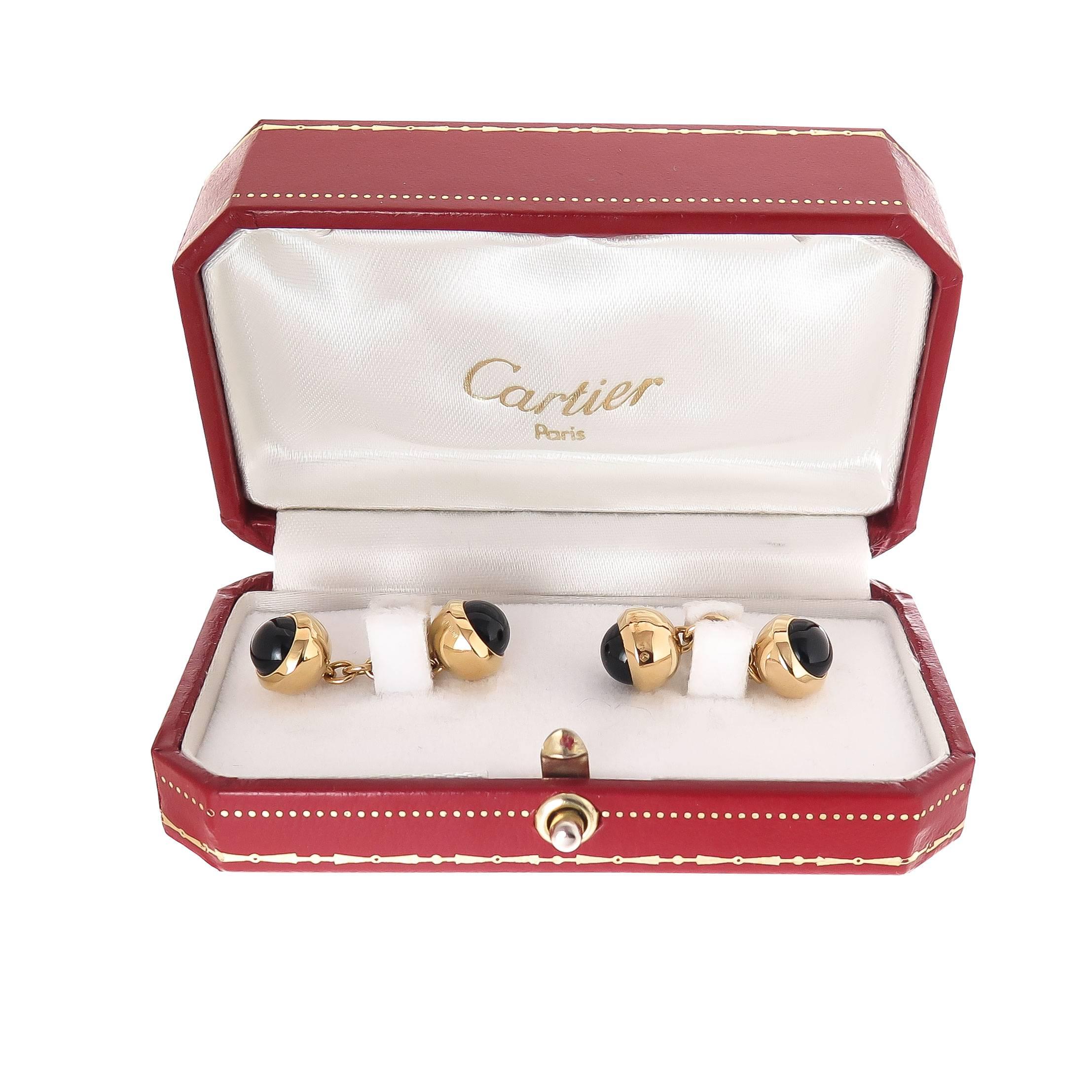 Circa 1990 Cartier 18K Yellow Gold and Onyx double sided Cuff-links, measuring 3/8 inch in diameter and set on each end with a round domed Cabochon Onyx. Signed, numbered and in the original Cartier presentation box.