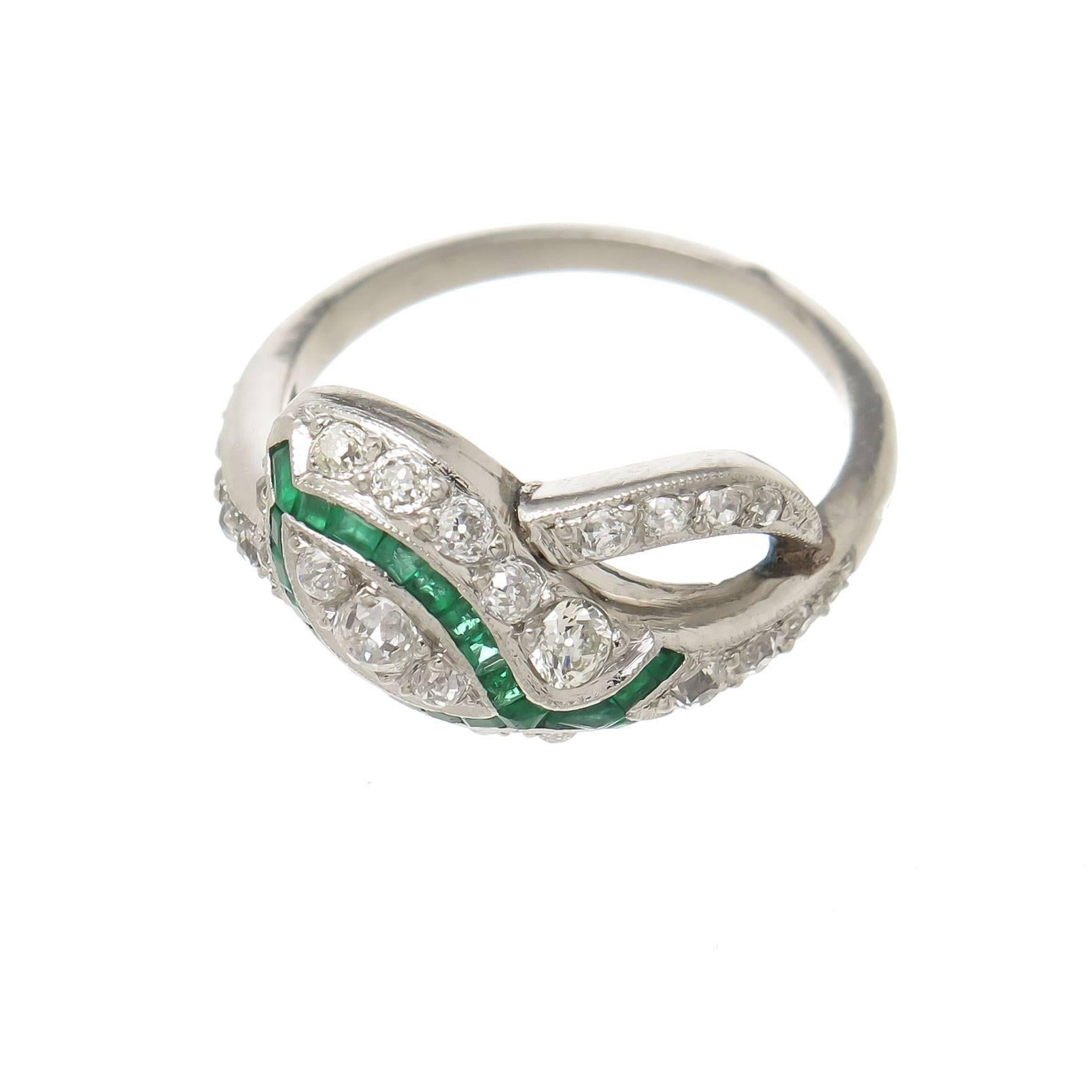 Circa 1930s Platinum Snake form ring,  measuring 3/4 inch across the top and set with old Mine cut Diamonds that are white and clean and total 1 carat, further set with square and fancy cut Emeralds of very nice Color. The inside of the shank having