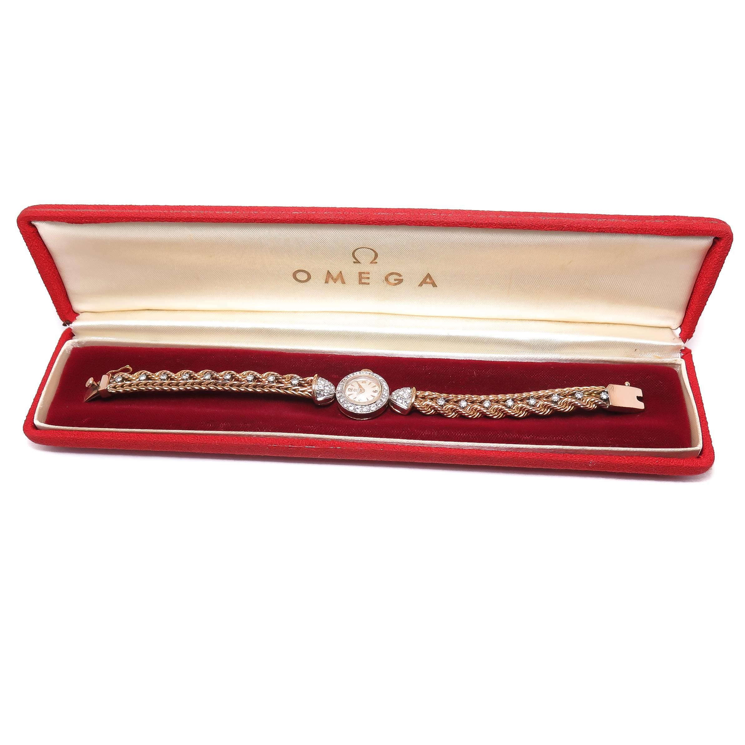 Circa 1940s Omega 18k Rose Gold Ladies Wrist watch, measuring 18 MM and attached to a Rose Gold Rope and Braided Bracelet, total length 7 inch. The bezel, Lugs and Bracelet are all original Factory set Diamonds totaling 1.70 Carat. 17 Jewel  manual