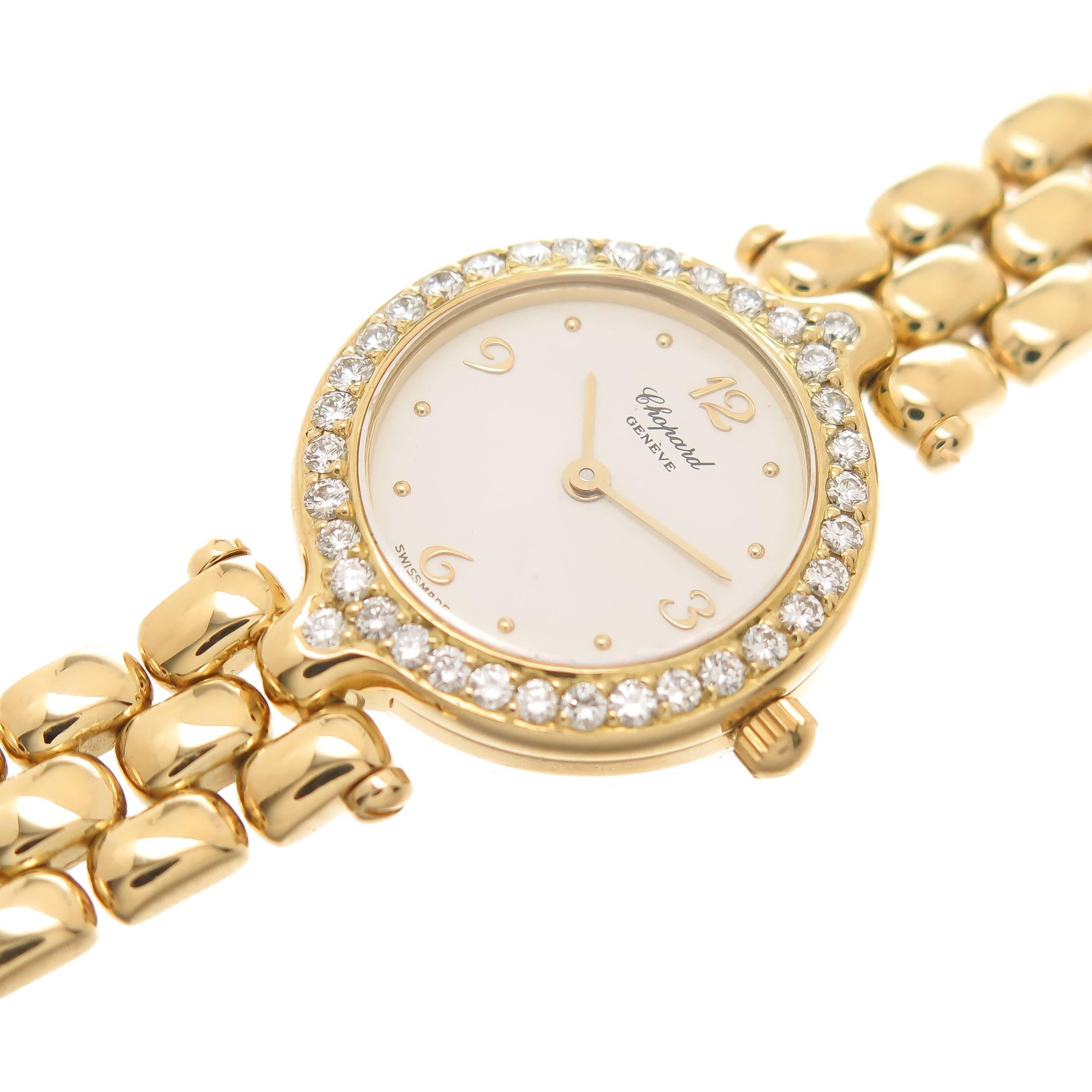 Circa 2005 Chopard Ladies 18K Yellow Gold Wrist watch, 20 MM water resistant case, Round Brilliant cut Diamond set bezel totaling 1 Carat. 3/8 inch wide Flexible link bracelet with safety lock clasp. Total length 6 3/8 inch. Quartz movement, white