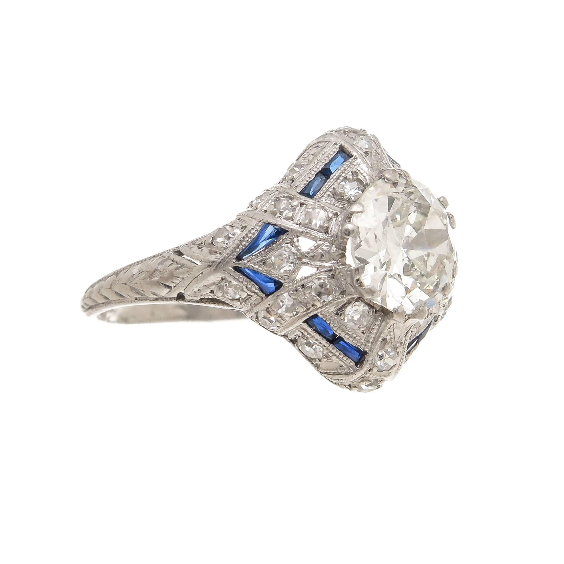 Circa 1930 Platinum Engagement Ring, centrally set with 1.20 carat European cut Diamond that is I in color and SI 2 in clarity. The mounting is further set with numerous smaller old cut diamonds and sapphires. An all original estate Ring. Finger
