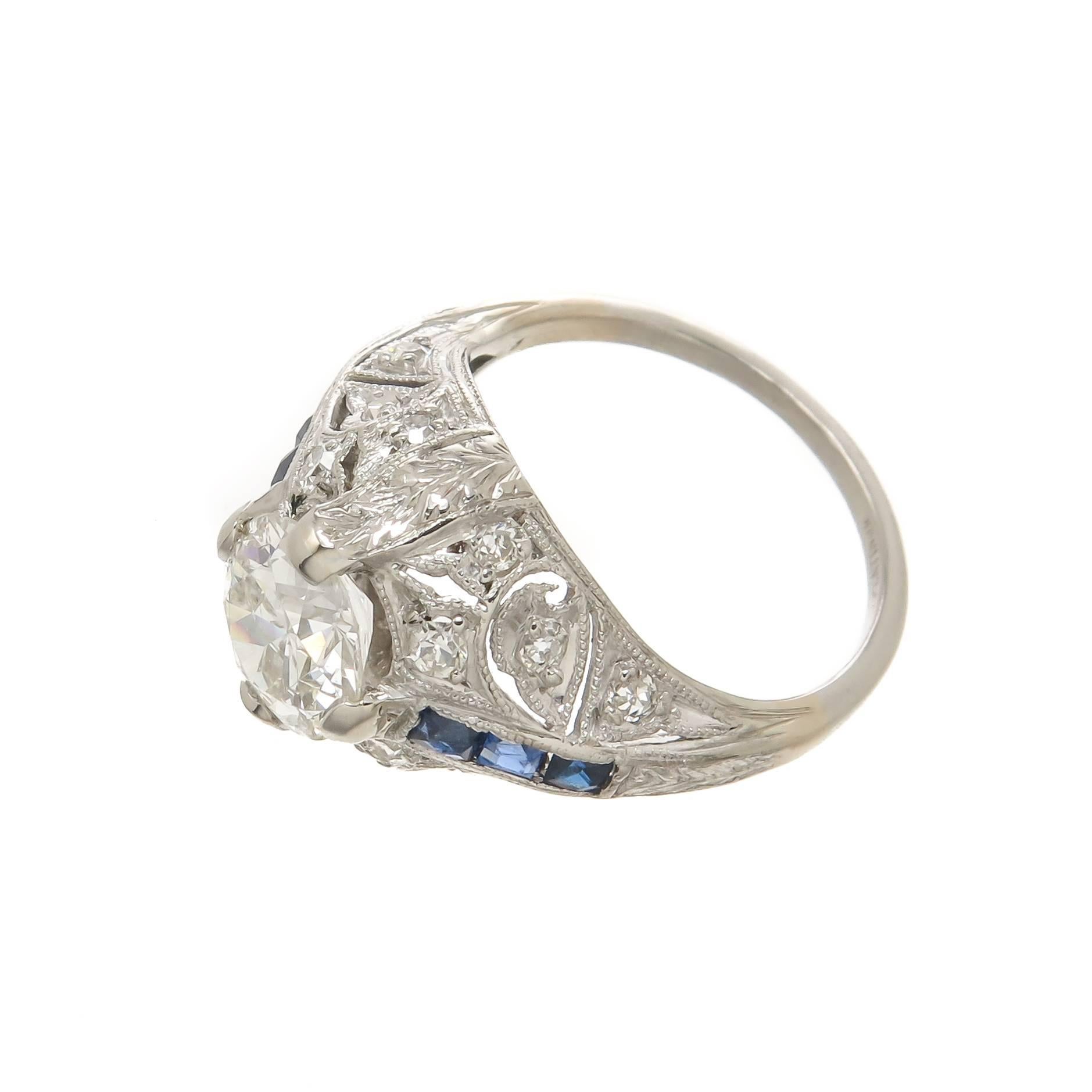 Circa 1930 Platinum Art Deco Engagement Ring, centrally set with a 1.27 Carat European cut Diamond Grading as I in color and SI2 in Clarity. Further set with smaller acs cent Diamonds, Baguette Sapphires and hand finished Gallery work. Finger size =