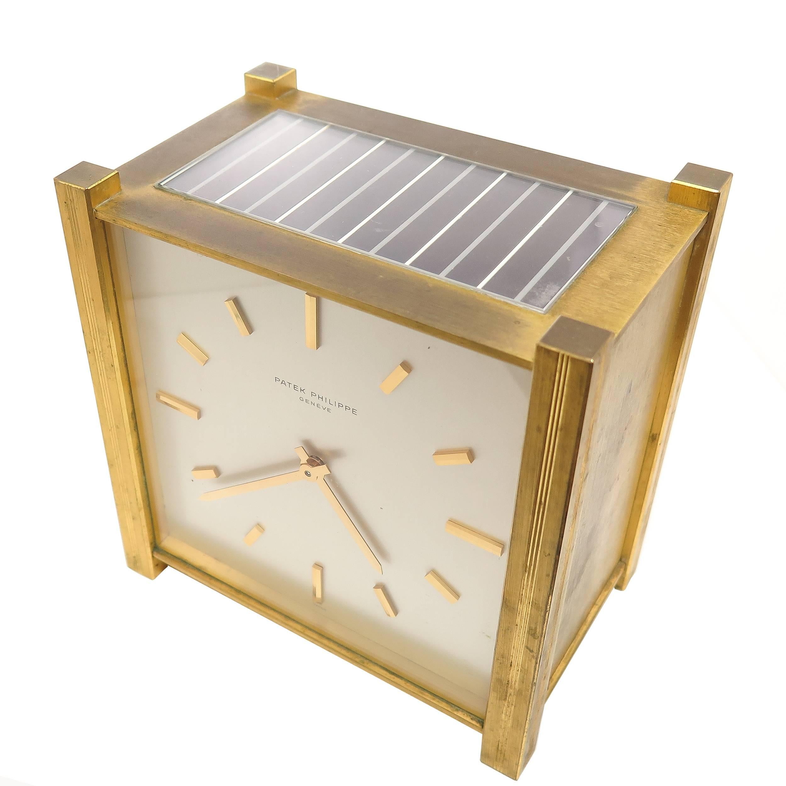 Circa 1970 Solar-powered electric table clock by Patek Philippe, Rectangular gilt brass brushed case measuring 5 5/8 X 5 5/8 X 3 1/2, with solar cells on the top, Excellent Mint Condition silvered Matt Dial with applied raised gilt indexes and
