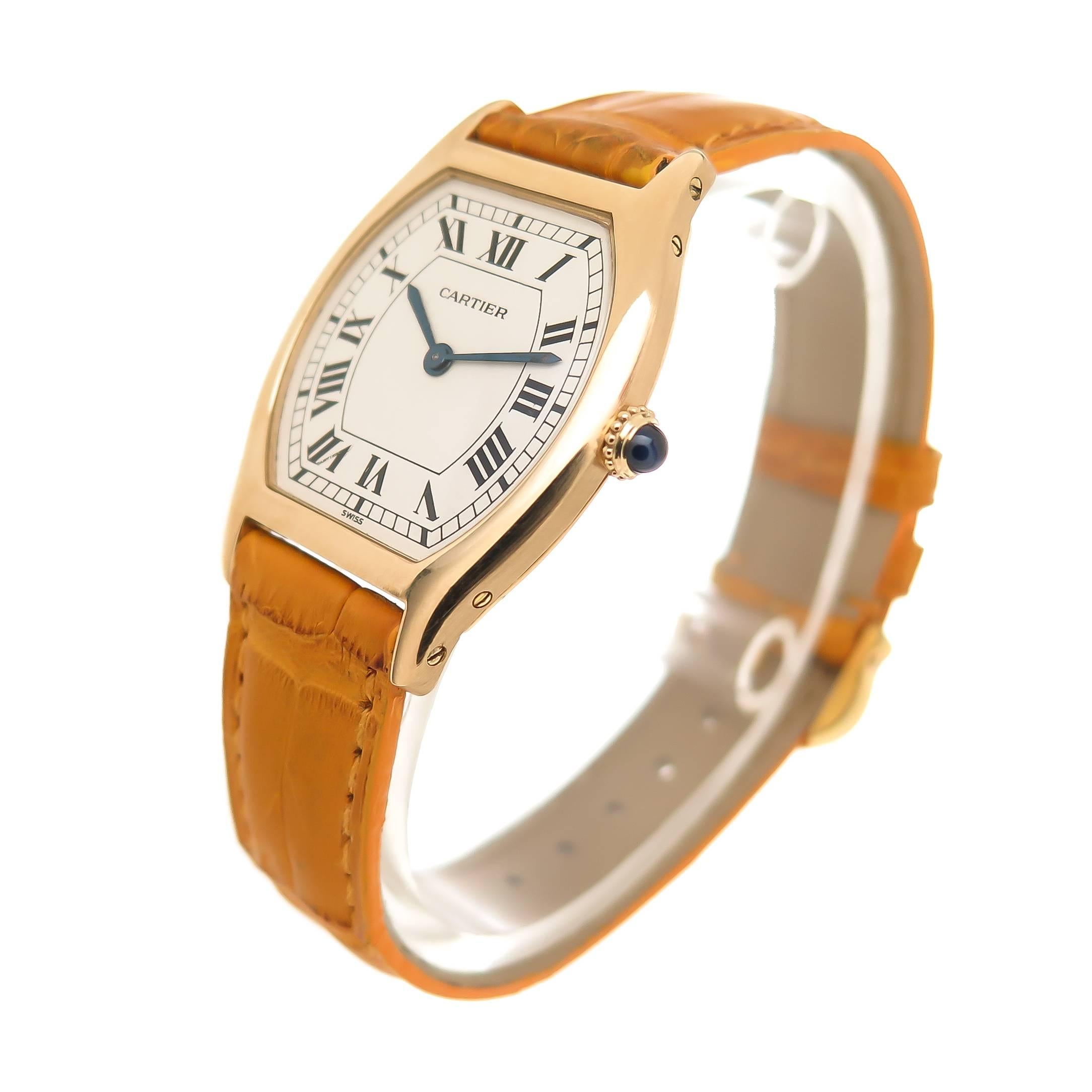 Circa 2000 Cartier Tortue 18K Yellow Gold Wrist watch, 36 X 28 MM Water Resistant case. White Dial with Black roman numerals. Manual wind mechanical movement, sapphire Crown. New Cartier Mustard color Textured Strap with Gold Plated Cartier Buckle.