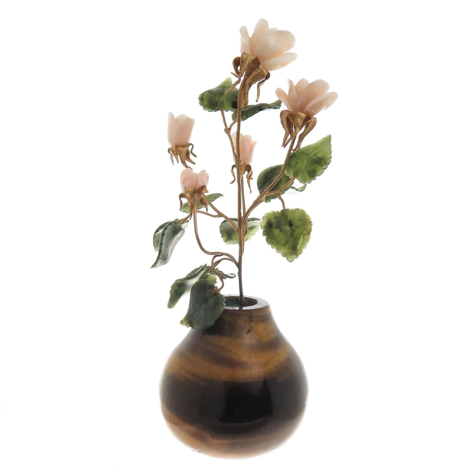 Circa 1970s Cartier Flowered plant in a Solid Tiger Eye Planter measuring 2 1/4 inch in height and 2 1/2 inch wide. The plant consists of Yellow Gold Branches and stems the flowers are carved Angel Skin Coral and the Leaves are Carved Nephrite.