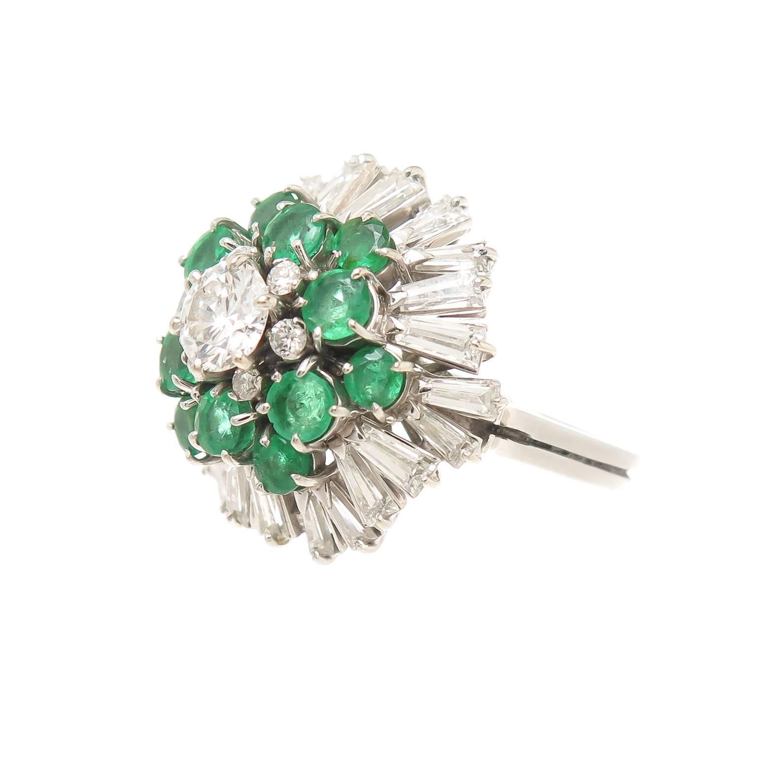 Circa 1960 18K White Gold Diamond and Emerald Ring owned and worn by Helena Rubinstein, Cosmetics Magnate and one of the worlds wealthiest woman. The domed cluster ring measures 3/4 inch across the top and is centrally set with a round brilliant cut