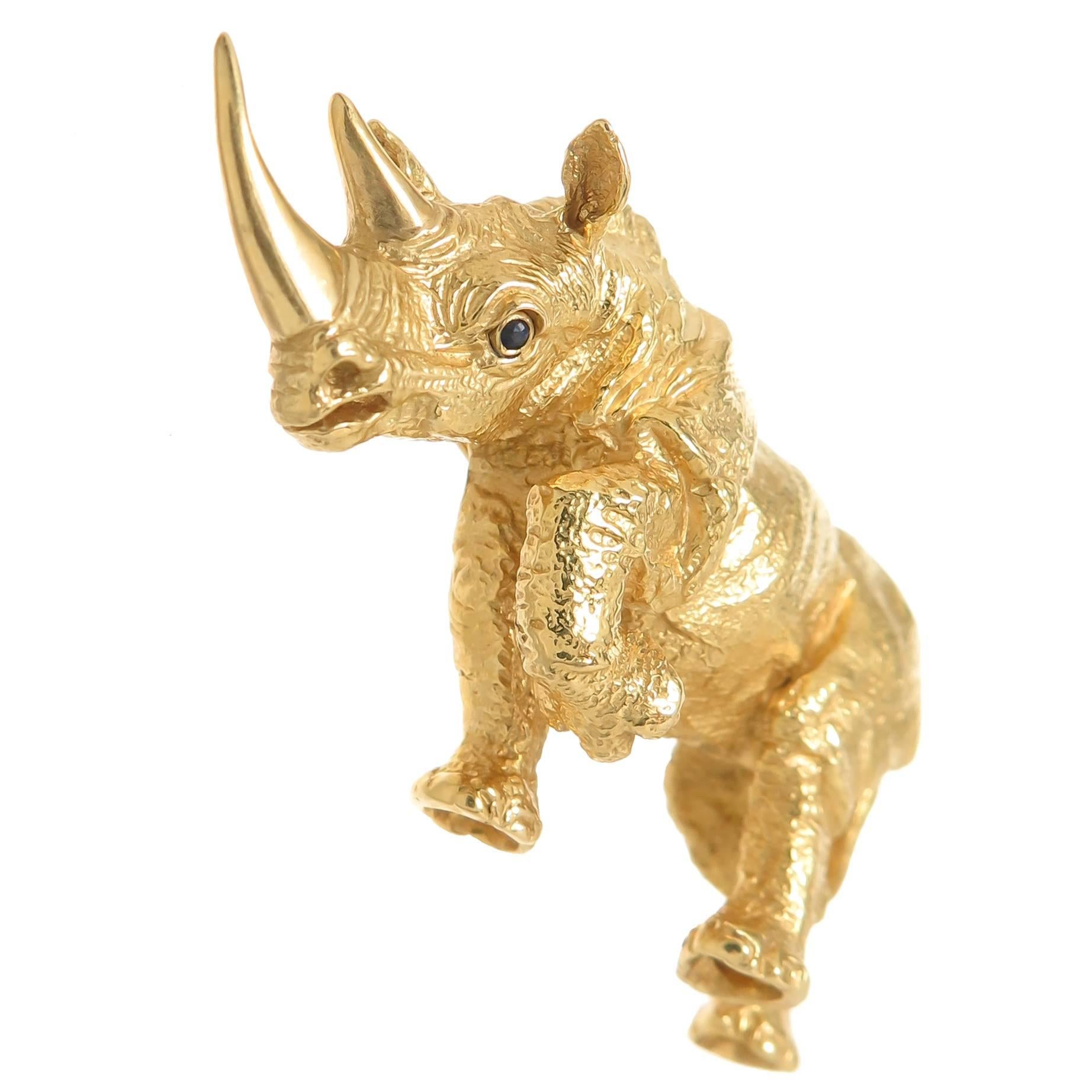 Circa 1980 Tiffany & Company 18K Yellow Gold Rhino Brooch measuring 2 1/4 inch in length. Very detailed with a textured finish and a Sapphire eye. Comes in original Tiffany presentation box.