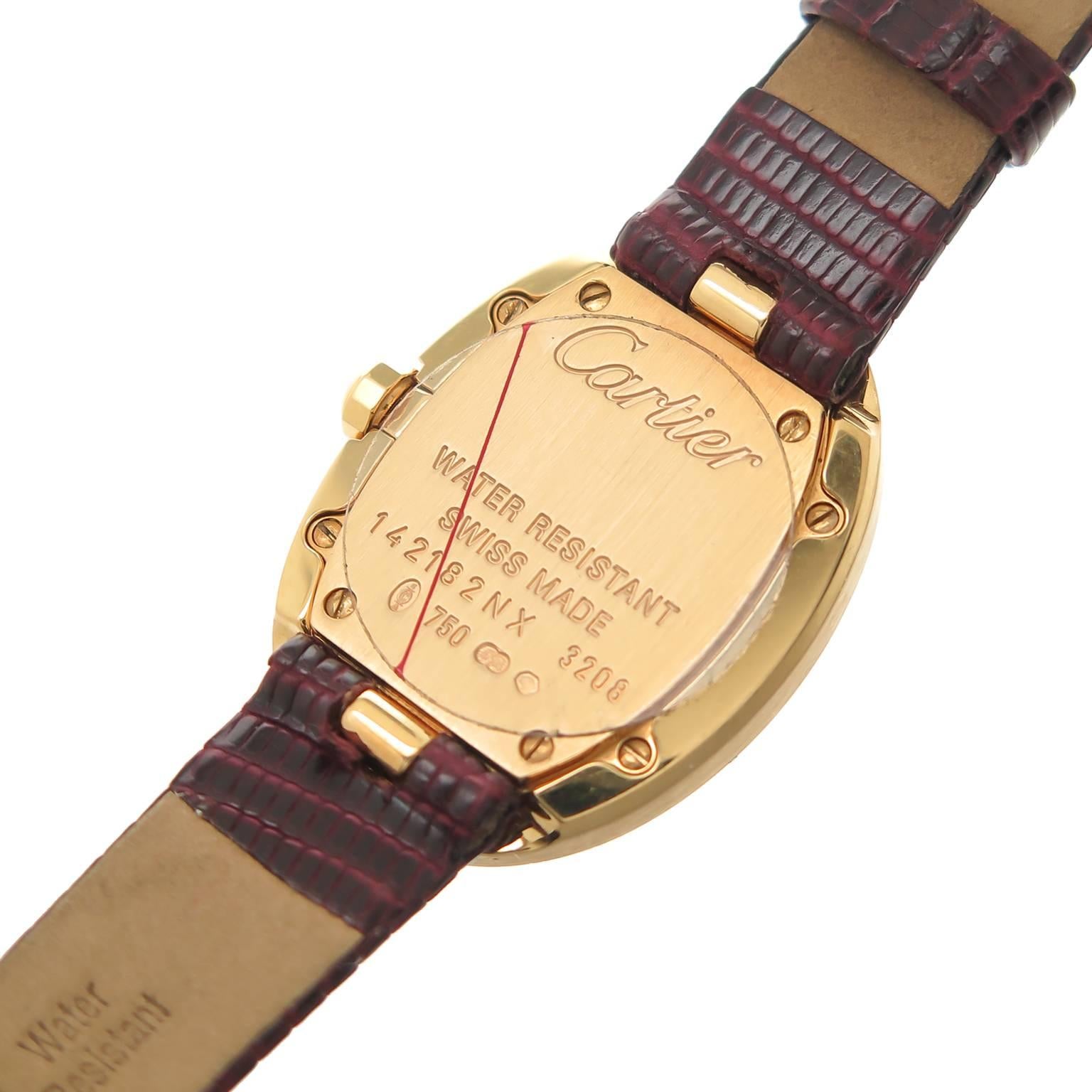 Circa 2000 Cartier Baignoire 18K Yellow Gold wrist watch, 32 X 28 MM water resistant case, Quartz movement, silvered  dial with Black Roman Numerals and a sapphire Crown. New, Hirsch Burgundy Lizard strap with original 18K yellow Gold Cartier Tang