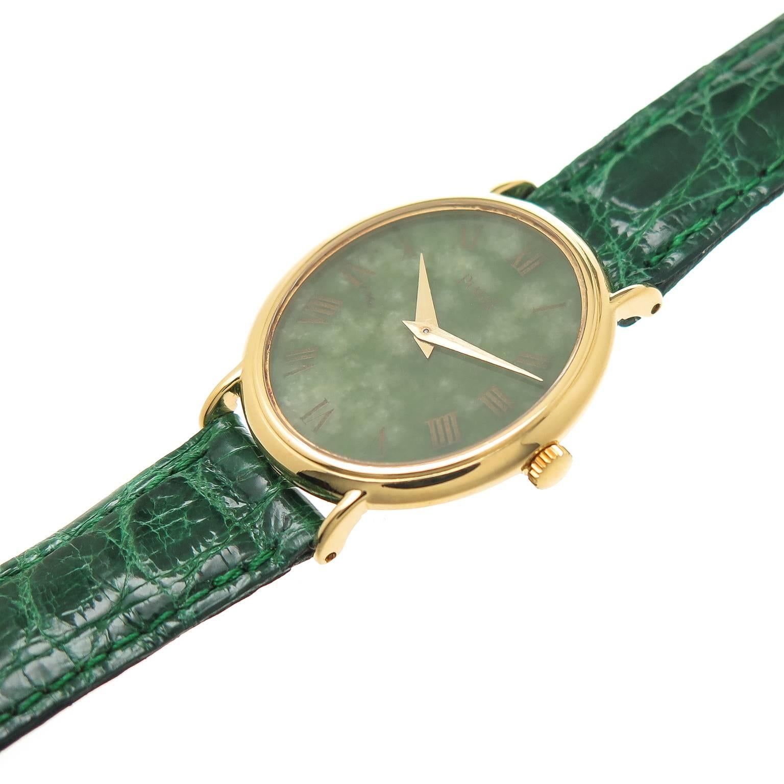 Circa 1980s Piaget Ladies Watch, 18K yellow Gold 30 X 24 MM Oval case. Green Nephrite Dial with Gold Roman Numerals, Mechanical, manual winding movement. New Debeers Green Crocodile Padded Strap. recently serviced and comes with a one year N. Green