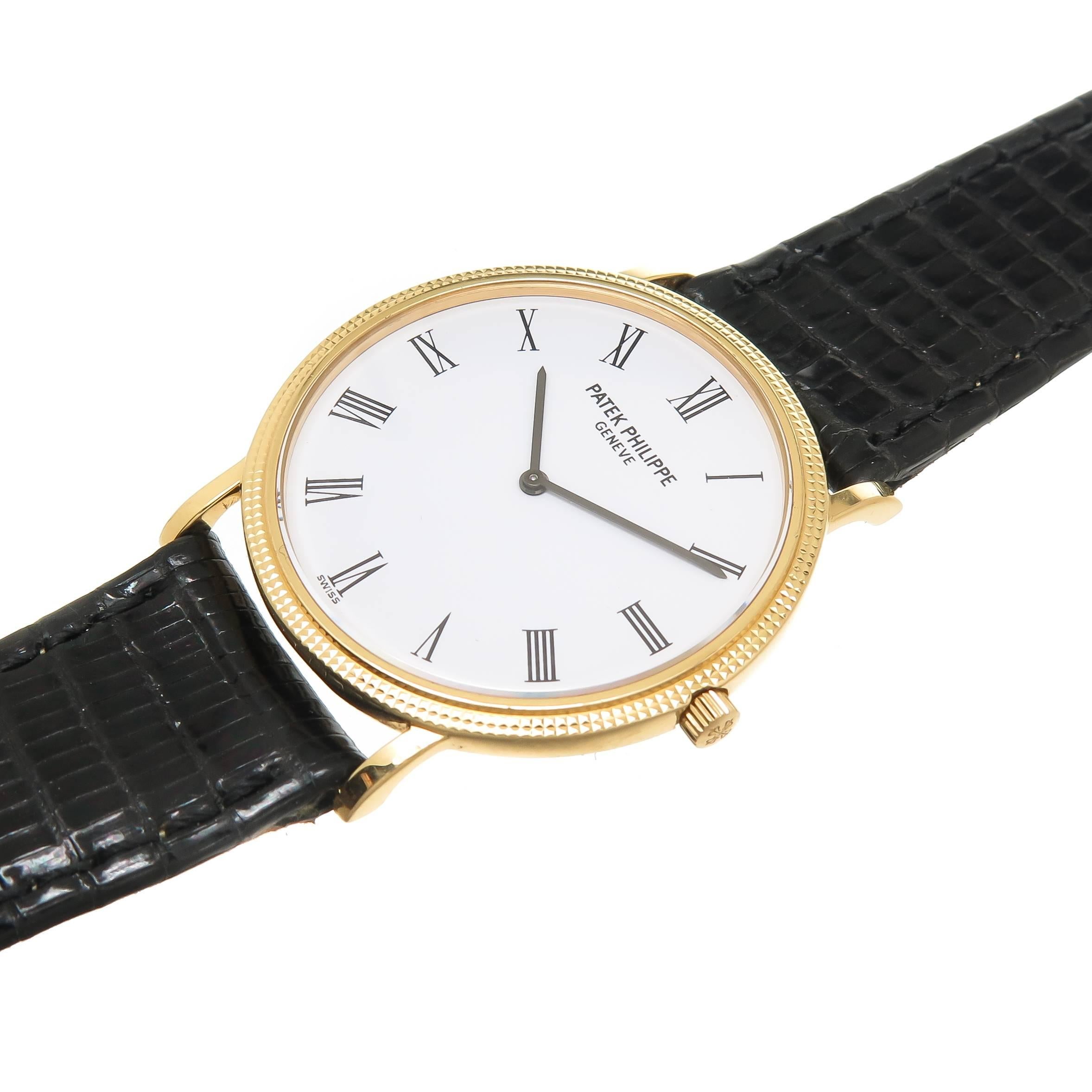 Circa 1990 Patek Philippe Calatrava Referenz 3520 mit Hobnail-Lünette:: 18K Gelbgold 32 MM wasserdichtes Gehäuse. Kaliber 177 Handaufzugswerk:: weißes Zifferblatt mit schwarzen römischen Ziffern. Neues schwarzes Eidechsenarmband mit Original Patek
