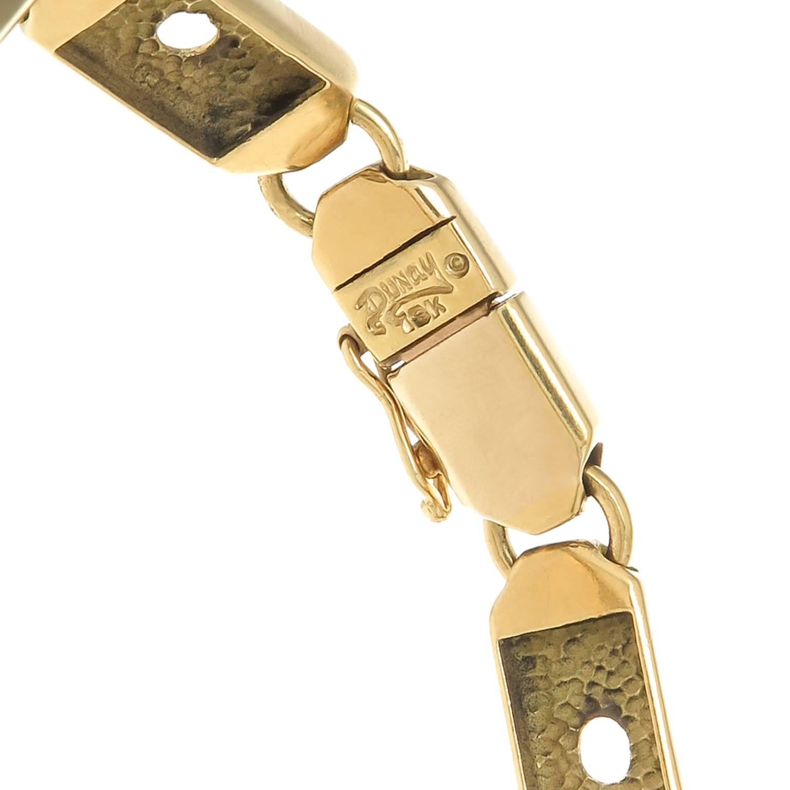 Circa 1980s Henry Dunay 18K Yellow Gold flexible link Bracelet, measuring 6 3/4 inch in length and 5/16 inch wide. The center of the bracelet spells out 