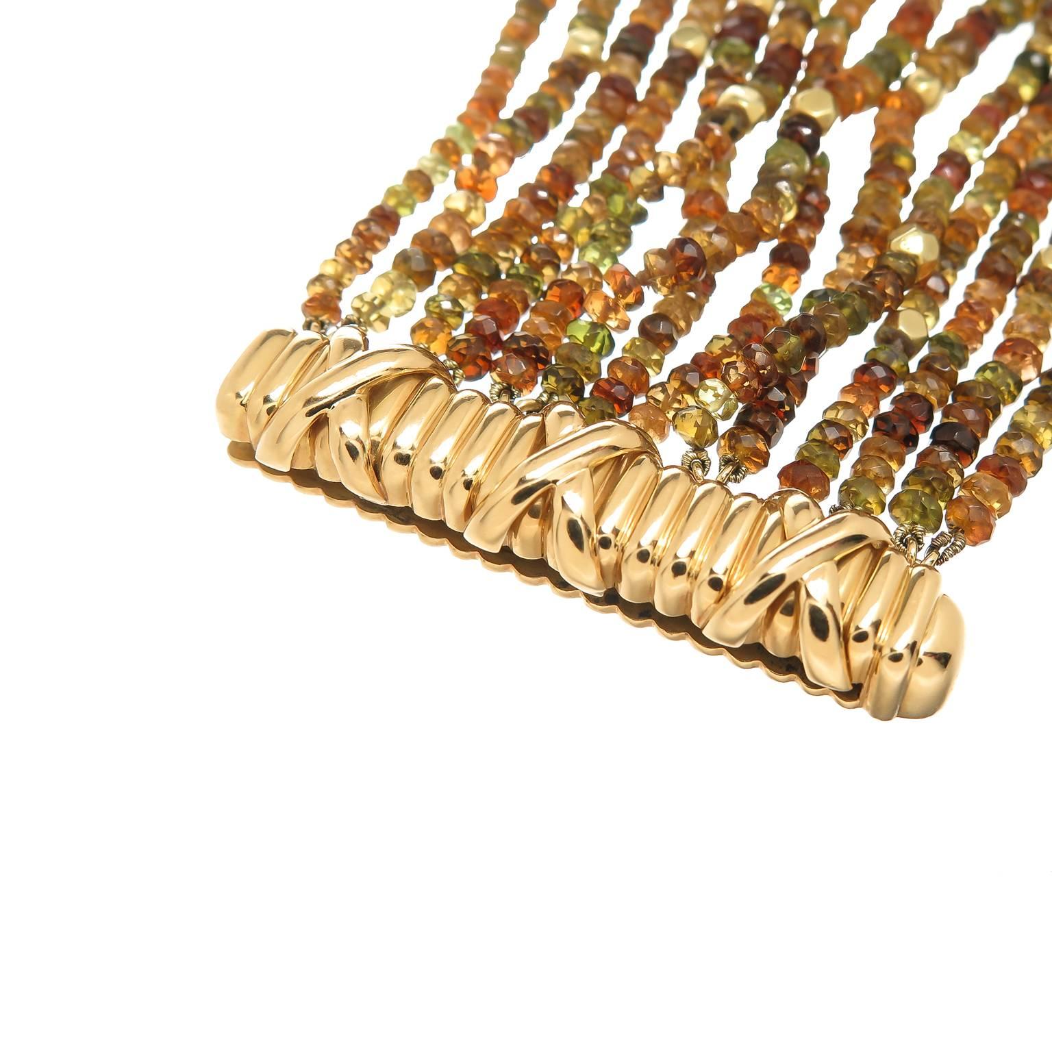 Circa 2000 Verdura 18K yellow Gold and Gemstone Bead Bracelet, having 14 Rows of faceted Roundel Citrine and Peridot  Beads and further accented with Gold faceted Beads, measuring 7 3/4 inch in length and 2 1/8 inch wide. Comes in original Verdura