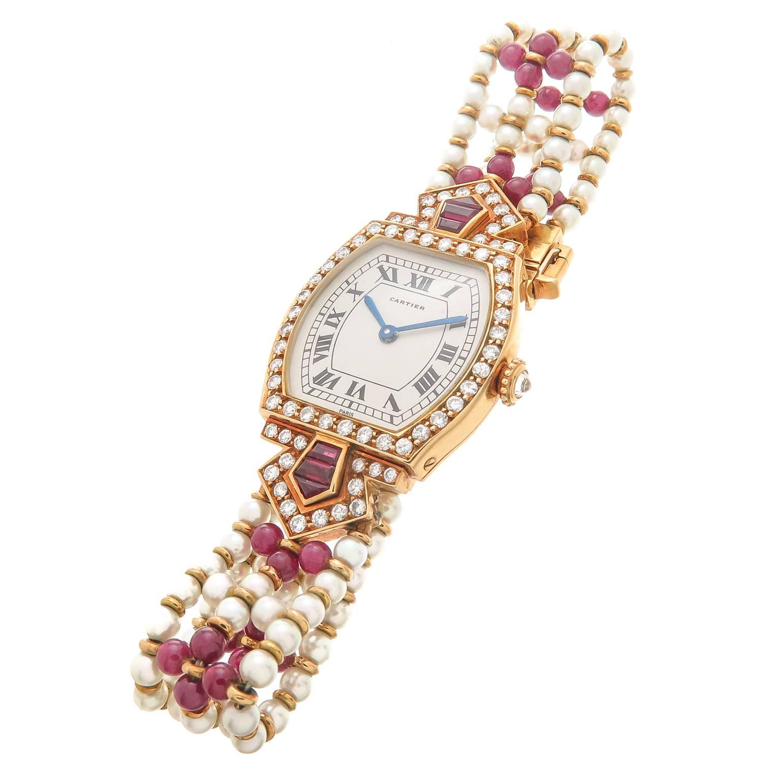 Circa 1990 Cartier Tortue Collection 18K yellow Gold and Gem set Ladies Wrist Watch. 40 MM X 23 MM Water Resistant case, set with Round Brilliant cut Diamonds and Fancy cut Rubies of very Fine Color and a Diamond set Crown. Manual wind Mechanical