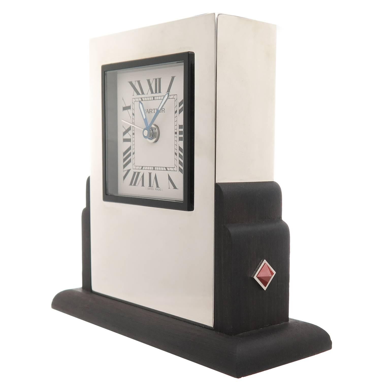 Circa 1990 Cartier  Art Deco style Desk clock, Silver plate, wood base and partial frame, Enamel bezel and having Coral inset decorations. Measuring 3 3/8 in height. Quartz Movement with alarm function, white dial with Black Roman numerals and