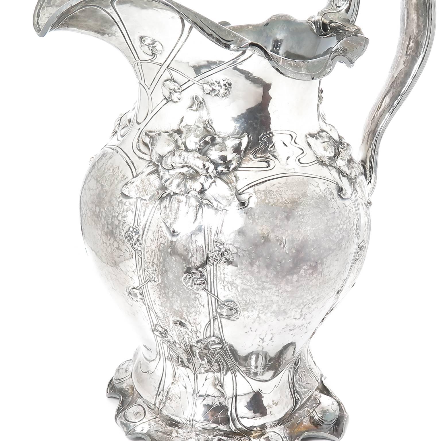 Circa 1900 Gorham Martele Sterling Silver Water Pitcher retailed by Spaulding & Company, measuring just under 11 inch in height and approximately 7 inch in diameter. Weighing 46 ounces and having very fine hand chased Flowers and decorations. This