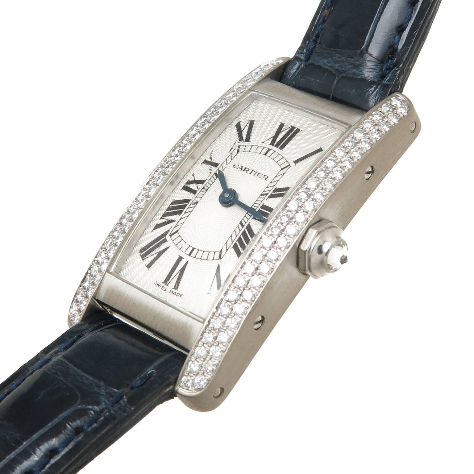 Circa 2005 Cartier Tank Americaine, 34 X 19 MM 18K White Gold Water resistant case Case, Double Row Factory set Diamonds and a Diamond Crown. Quartz Movement, silvered Engine turned Guilloche Dial. Cartier Dark Blue Textured Strap with Original