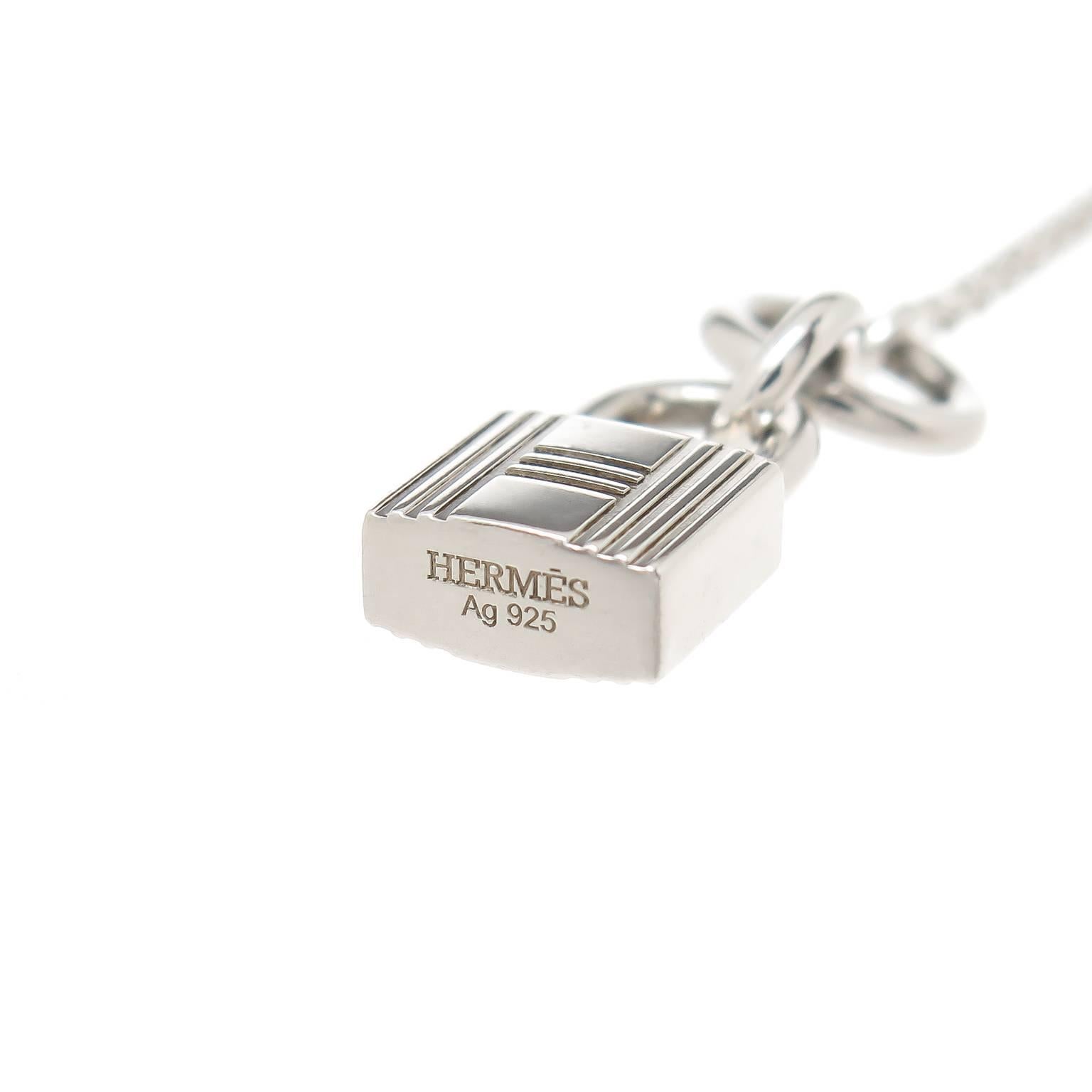 Circa 2014 Hermes Sterling Silver Kelly Cadenas Lock Pendant, measuring 3/4 inch in length and suspended from a 16 inch link chain with Toggle Fastener. This piece is new, unworn and comes in the original Hermes presentation box.