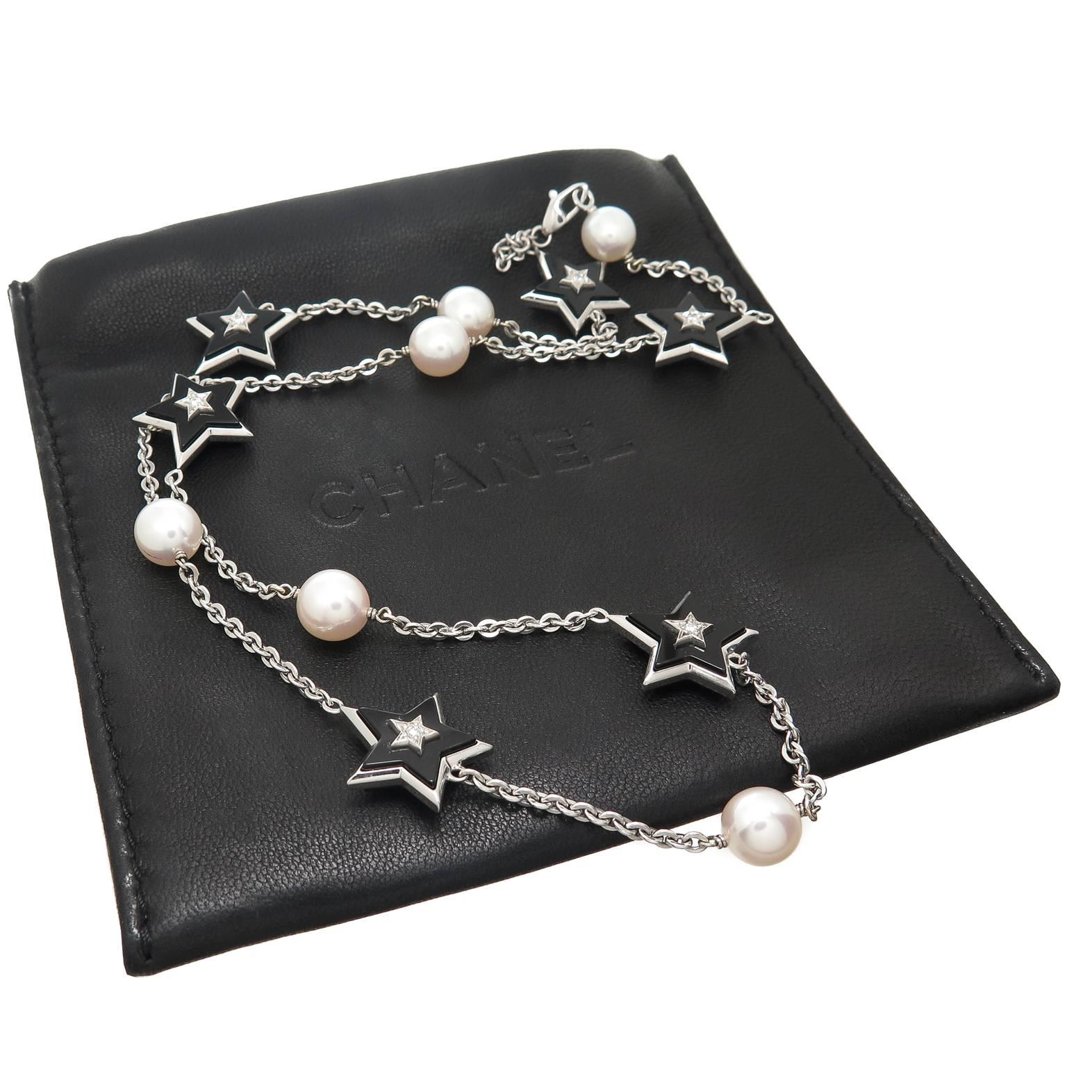 Circa 2005 Chanel 18K White Gold Necklace having double sided 5 point stars of Black Onyx measuring 1/2 inch and set with a Round Brilliant cut Diamond, further alternating with a fine luster 8 MM pearl. Total Necklace length 19 inch, signed and