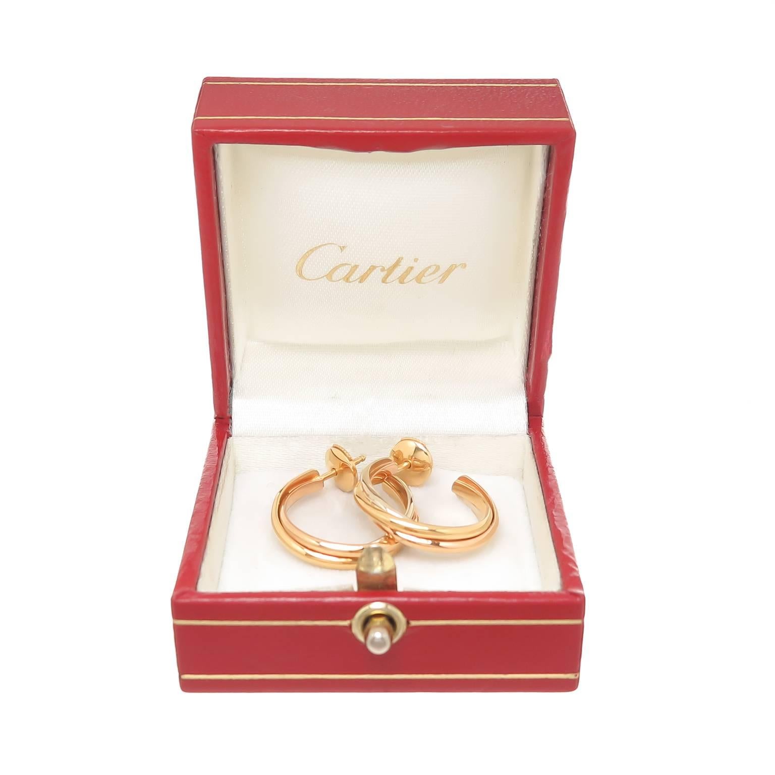 Circa 2005 Cartier Trinity collection 18K White, Yellow and Pink Gold Hoop Earrings, measuring 3/4 inch in diameter and weighing 8 grams. 
signed, numbered and come in a Cartier Gift Box.