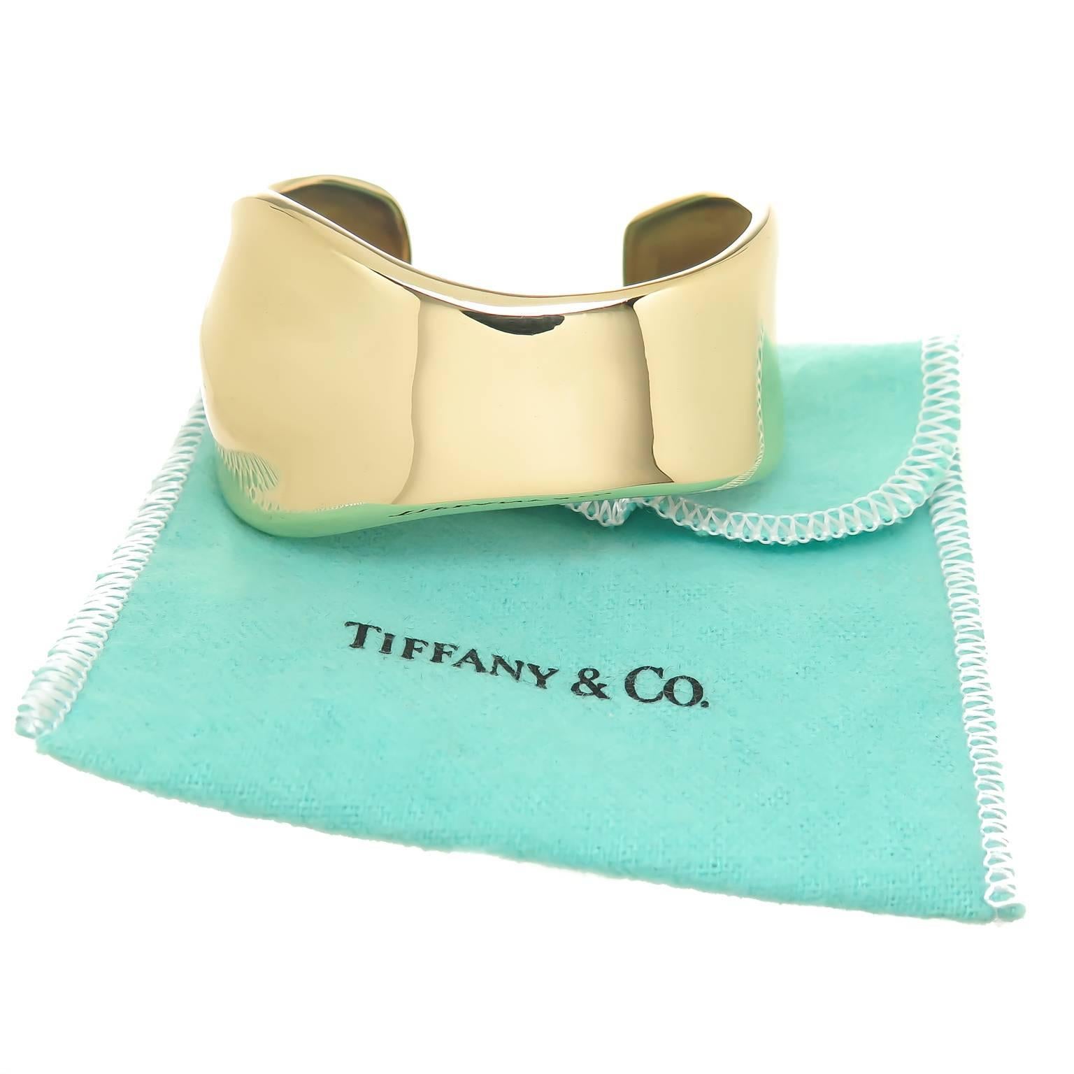 Circa 1990 Elsa Peretti for Tiffany & Company 18K Yellow Gold Bone Cuff Bracelet. measuring 1 3/8 inch wide and having an opening that measures 1 inch. Weighing 75.5 Grams and comes in the original Tiffany Felt Pouch. 