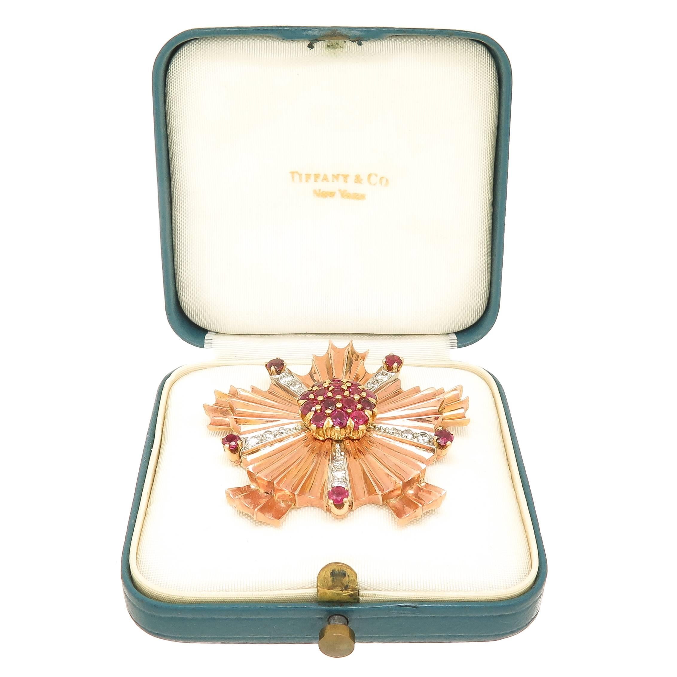 Circa 1940 Tiffany & Company 14K Rose Gold Brooch in a very strong Retro period style, measuring 1 5/8 inch in Diameter and set with older cut Diamonds totaling .50 Carat and further set with Very Fine Color Rubies. Comes in Original Tiffany &
