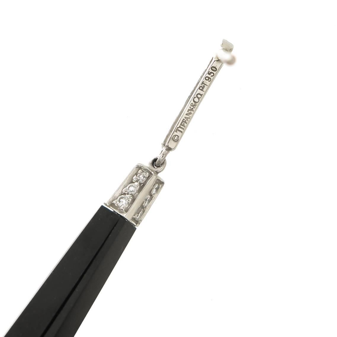 Circa 2000 Tiffany & Co. Platinum and Onyx Long Dangle Earrings, measuring 2 1/2 inch in length and 1/4 inch in diameter.The Onyx has Faceted Corners and ends. The top section is set with Round Brilliant cut Diamonds totaling 1/2 Carat. Pressure fit