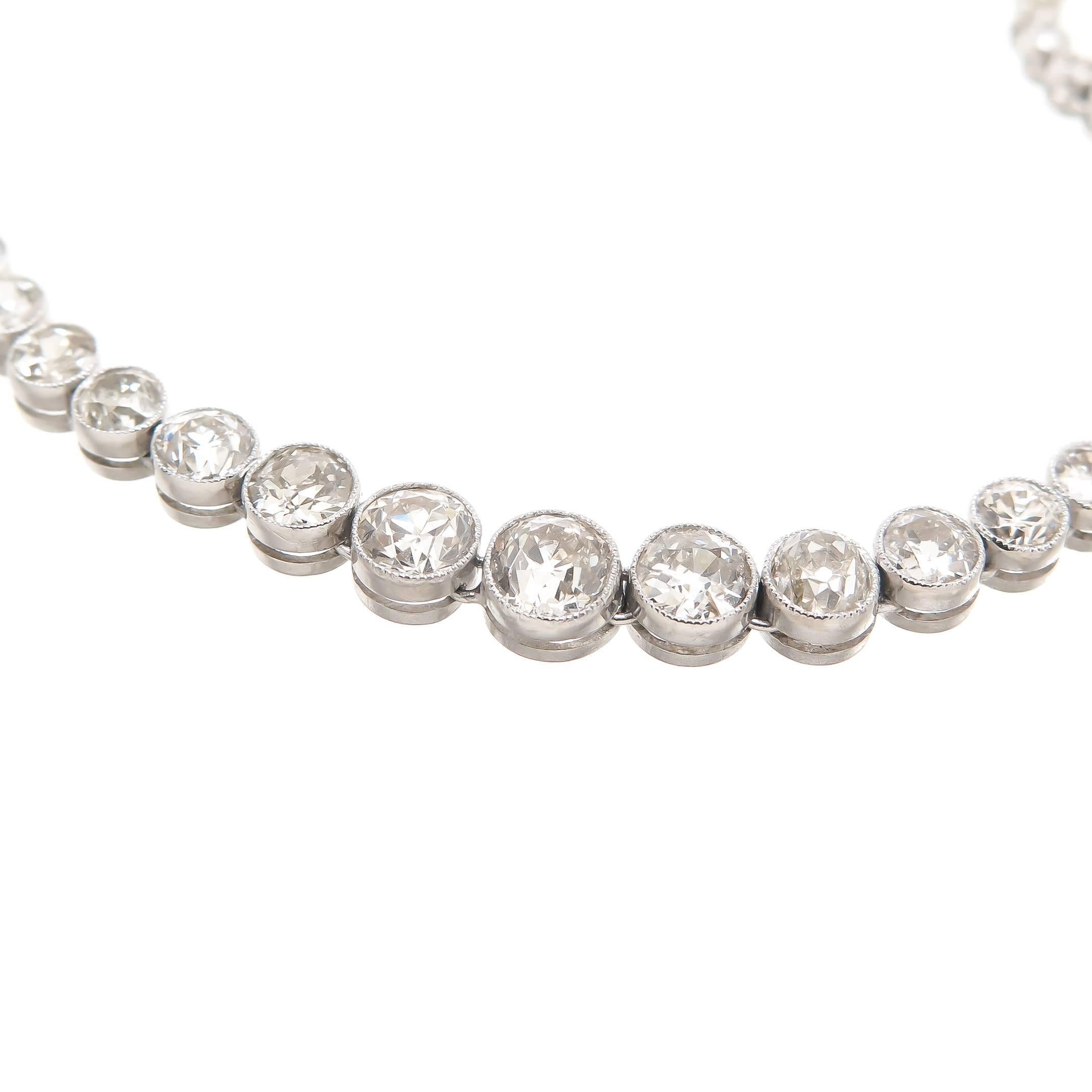 Platinum Riviere graduated necklace, Bezel set with old Mine cut Diamonds, and having Milgrain edges. Total  Diamond Weight 11.24 Carats and grading as H to K in color and VS to SI in clarity. Total necklace length 16 inch.
