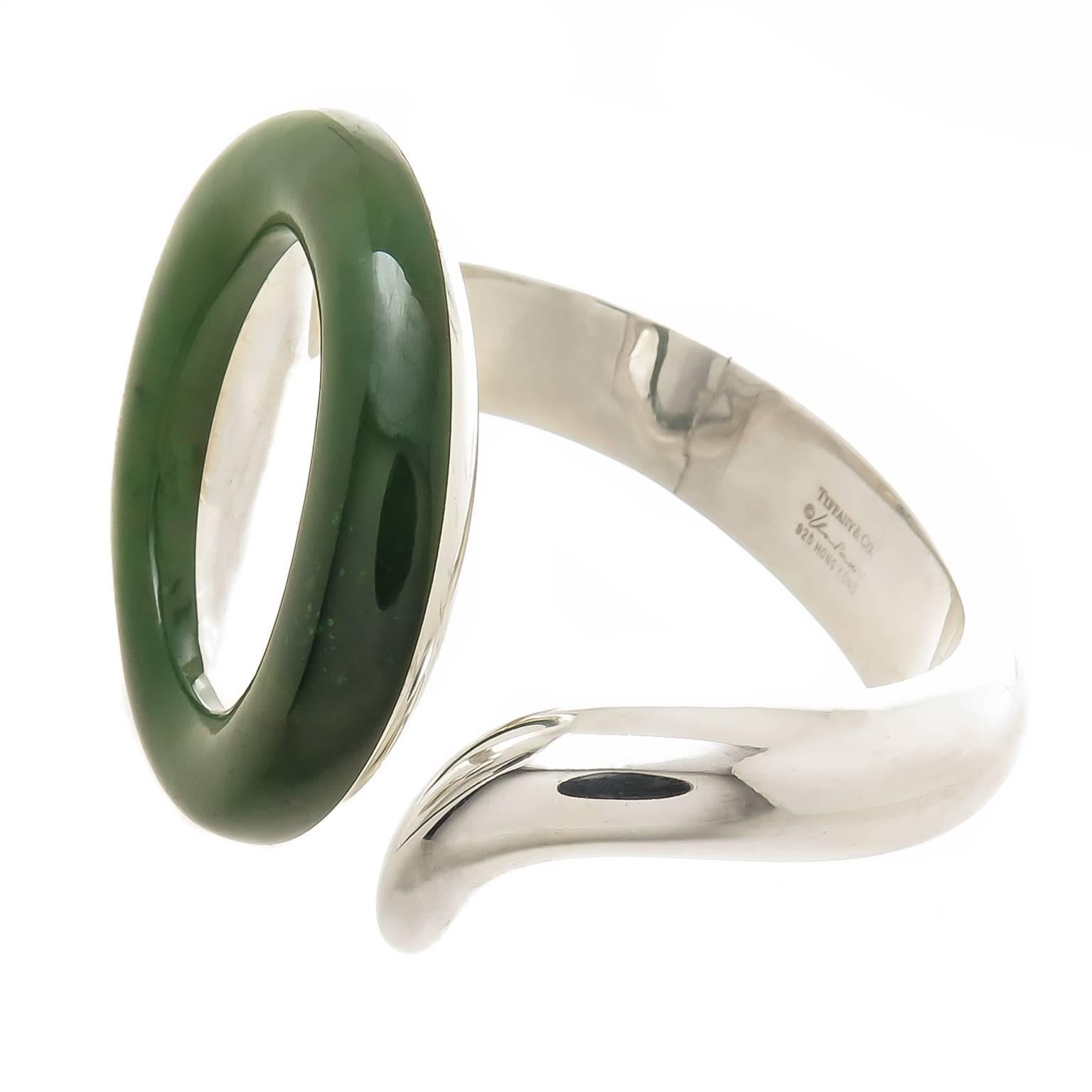 Circa 1990 Elsa Peretti for Tiffany & Company Sterling Silver and Jade Sevillana collection Bracelet. Deep Rich Green Jade circle measuring 2 X 2 Inch. Thick Solid construction with an inside measurement of 6 1/2 inch and having a hinge for easy on