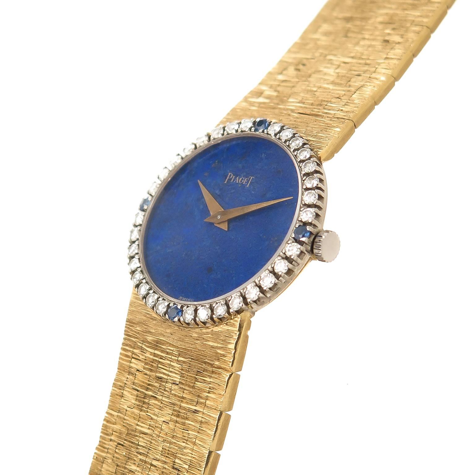Circa 1970s Piaget Ladies Wrist Watch, 24 MM 18K yellow Gold Water resistant case with Diamond and Sapphire Bezel, 17 jewel manual wind Movement, Lapis Lazuli Dial with Gold Hands. 5/8 inch wide signed Piaget 18k yellow Gold bracelet. Total watch