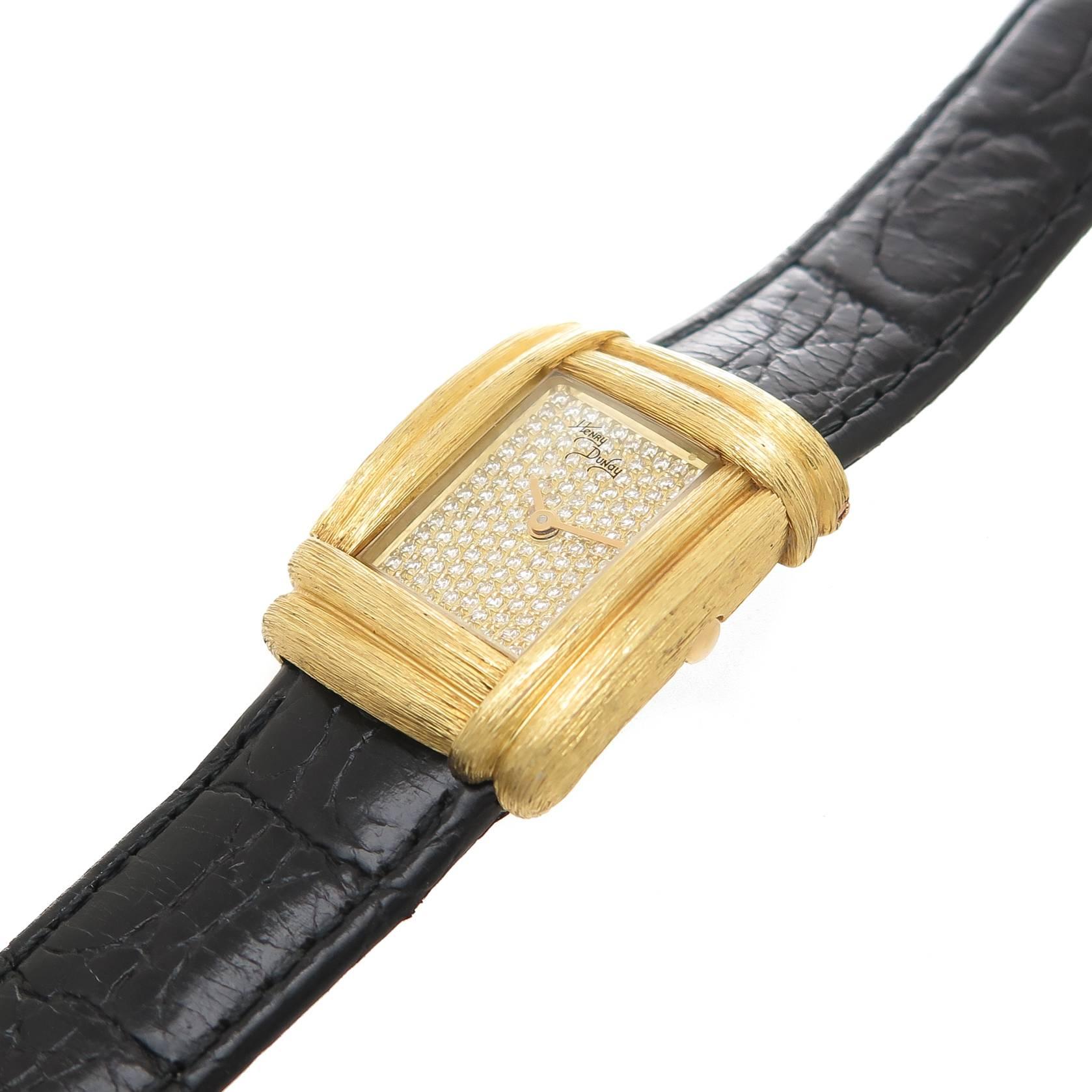 Circa 1990s henry Dunay ladies Wrist watch with Sabe finish, measuring 1 1/8 X 7/8 inch. Quartz Movement, Diamond pave Dial. Black leather Strap with 18k yellow Gold Dunay fold over Clasp, adjustable to fit most any wrist, recently serviced and