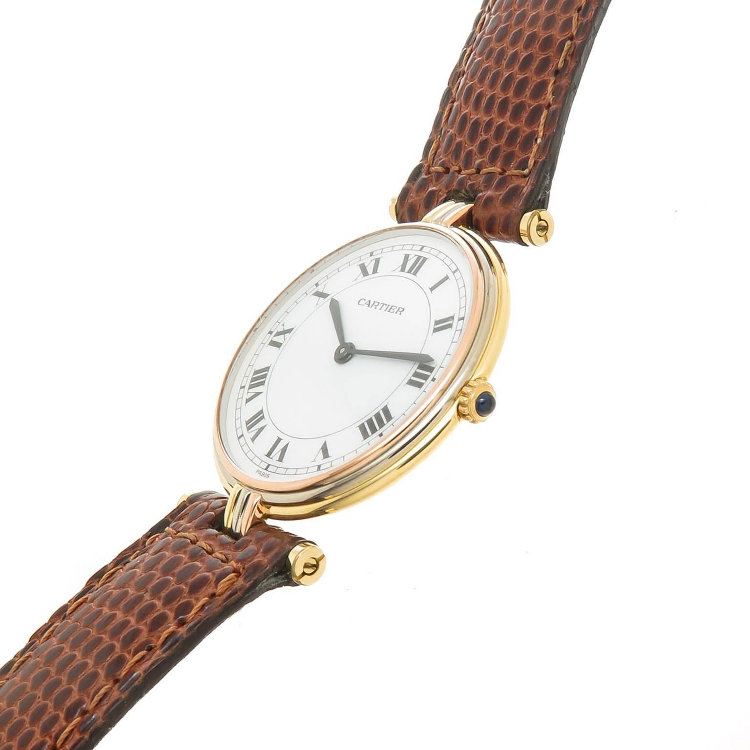 Circa 1990s Cartier 18K Yellow, White and Rose Gold Vendome, Trinity Watch. 2 piece 30 MM water resistant case, Quartz Movement, White Dial with Black Roman Numerals and a Sapphire set crown. Original Brown Lizard strap with a Gold Plate Cartier